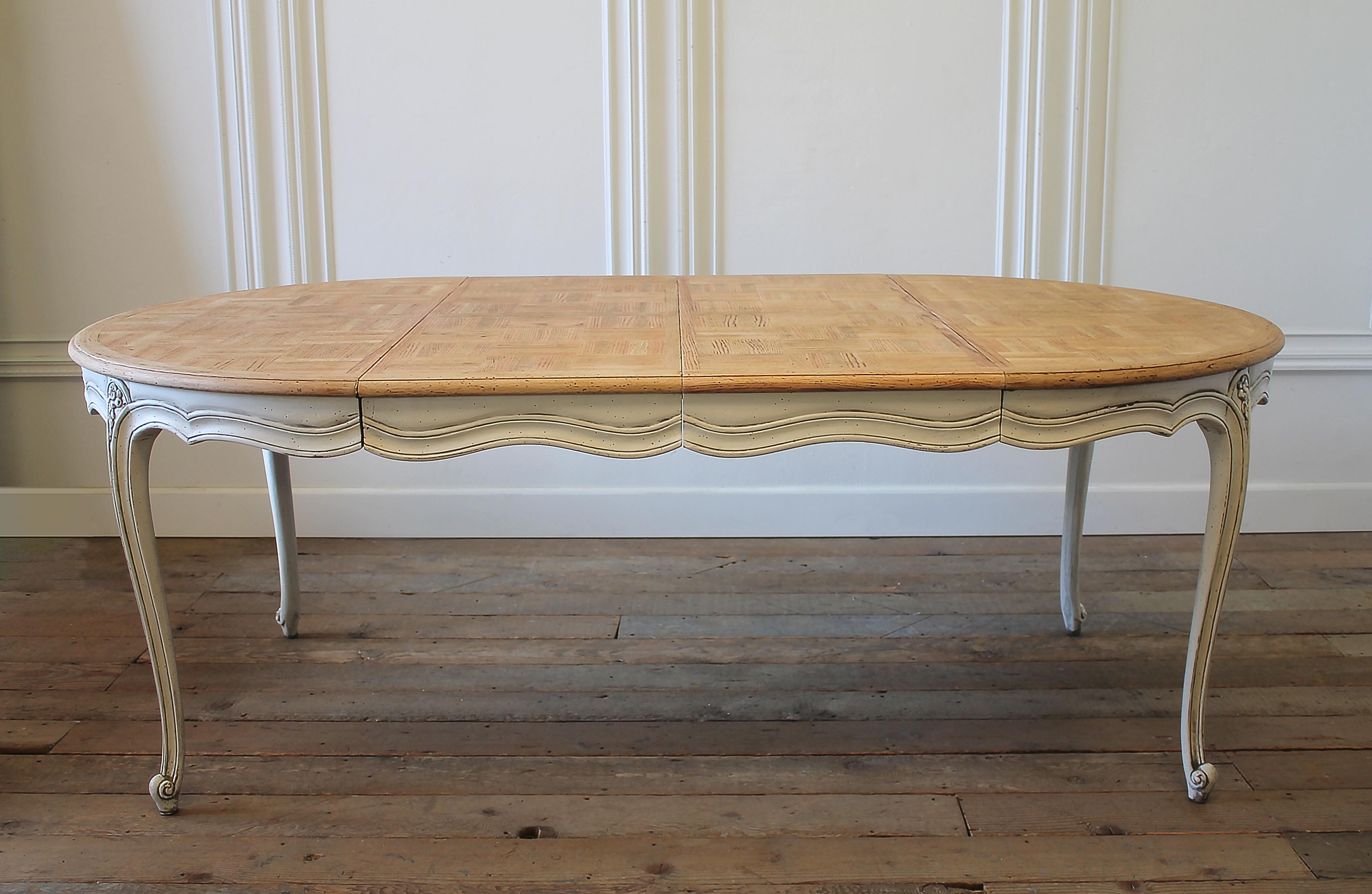 20th century French Provincial parquetry dining table.
Beautiful French Provincial dining table with natural wood parquetry top. Table base has been painted in a soft oyster white finish, with subtle distressed edges, and finished with an antique