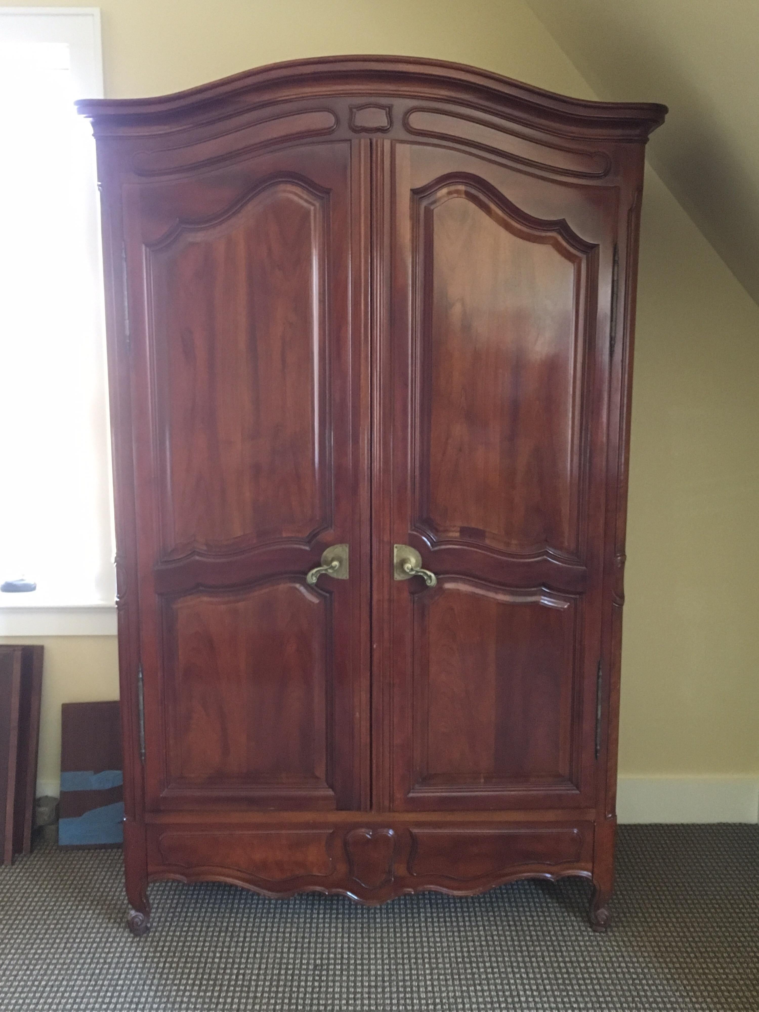 20th century French Provincial style walnut armoire by John Widdicomb, marked with plaque.
Behind two doors:
Upper area is fitted with rail to hold hanging clothes.
Plus two adjustable shelves 18.25