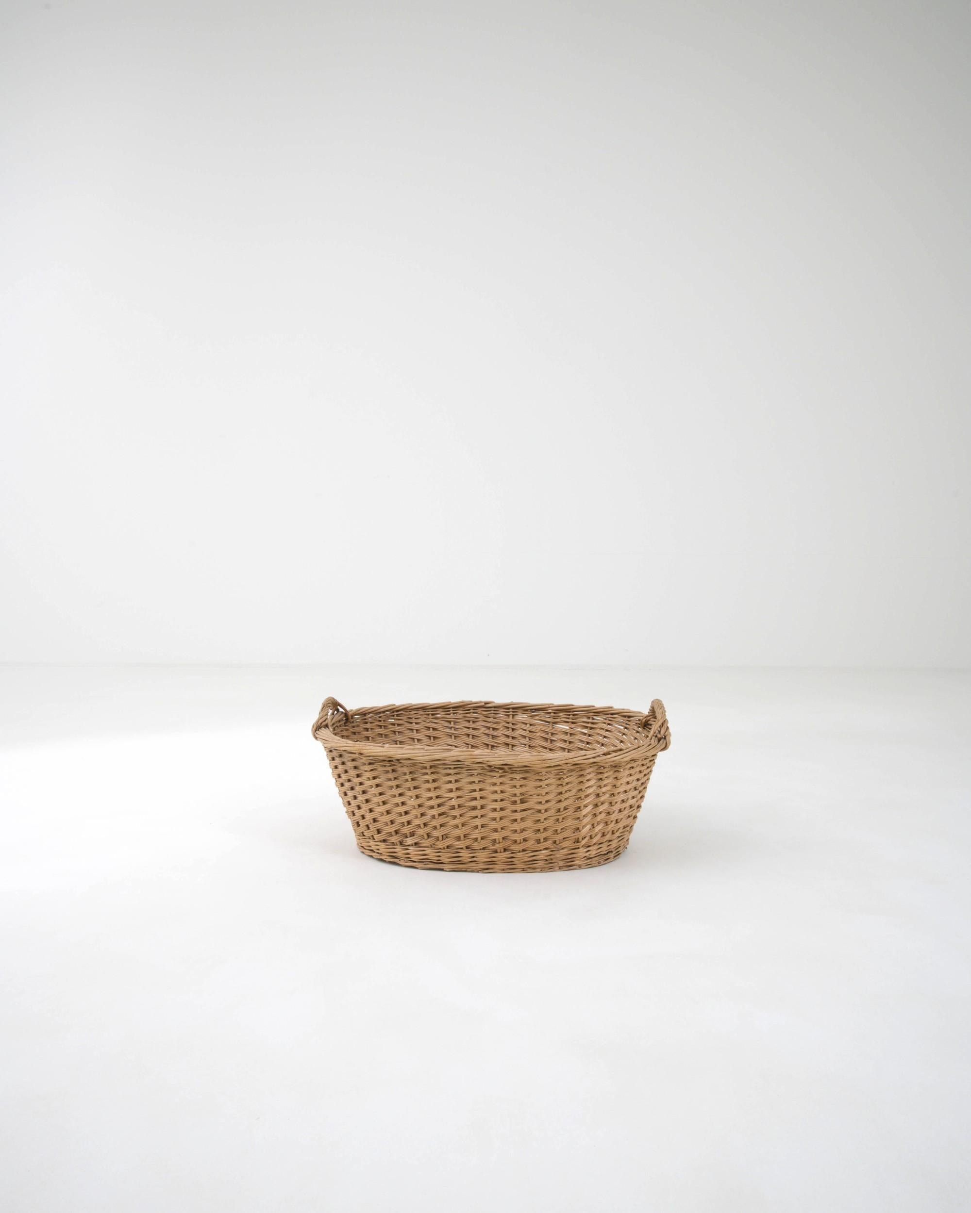 This Provincial wicker basket evokes the rustic simplicity of a bygone age. Made in France in the 20th century, this piece was once likely used for fruit-picking; the form evokes the abundance of the orchard and the golden warmth of summer’s end.