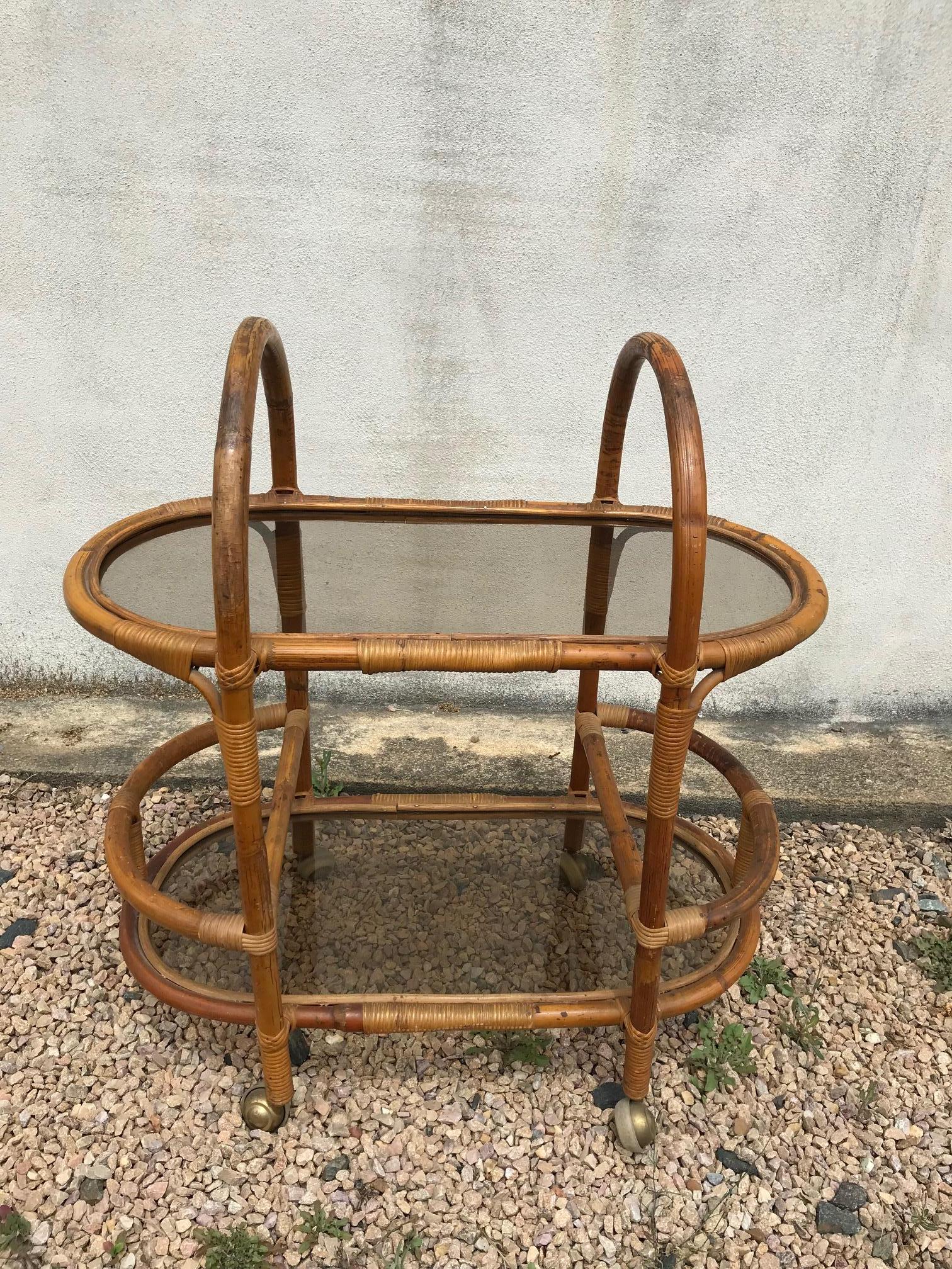 Nice 20th century French rattan and glass rolling dessert table from the 1960s. 
Two smoked glass top. Two parts to put bottles.