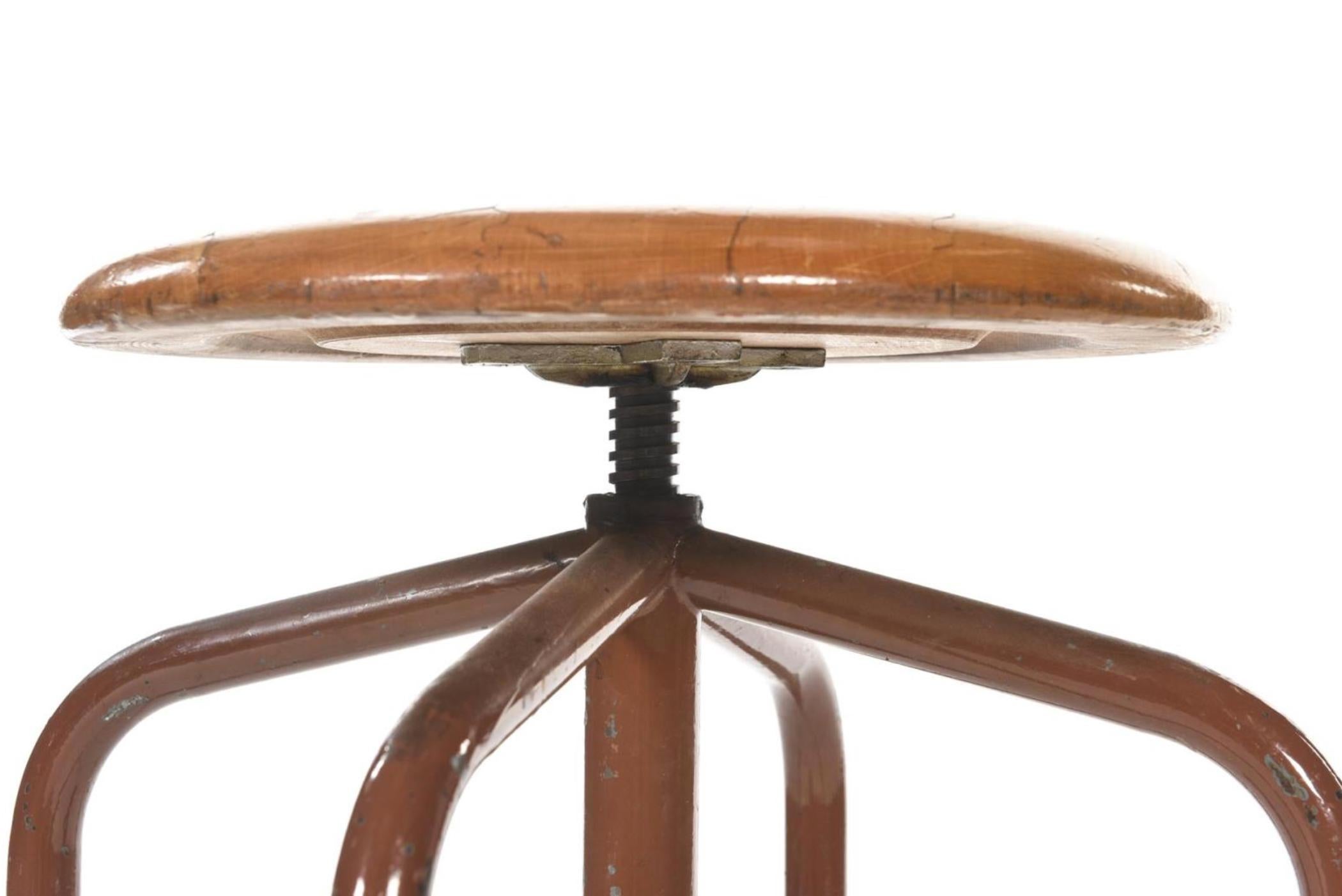 Adjustable round stool made of massive wood raised on four stabile metal legs.
France, circa 1950.