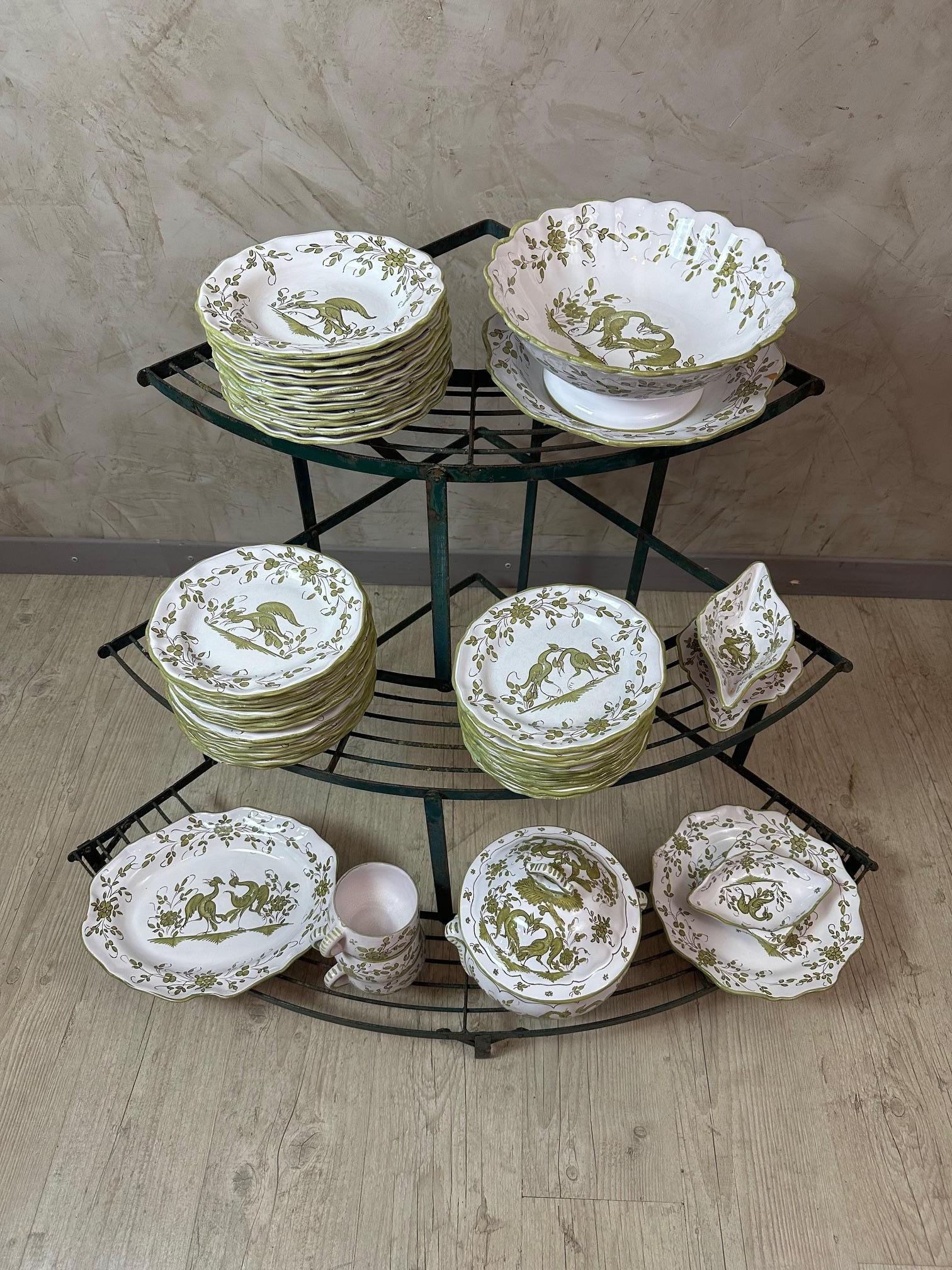 Magnifique service de table en faïence de Moustiers, fabriqué à la main en France, composé de 49 pièces coordonnées. Délicatement peinte en vert avec des motifs provençaux traditionnels, présentant des scènes animales et florales caractéristiques du
