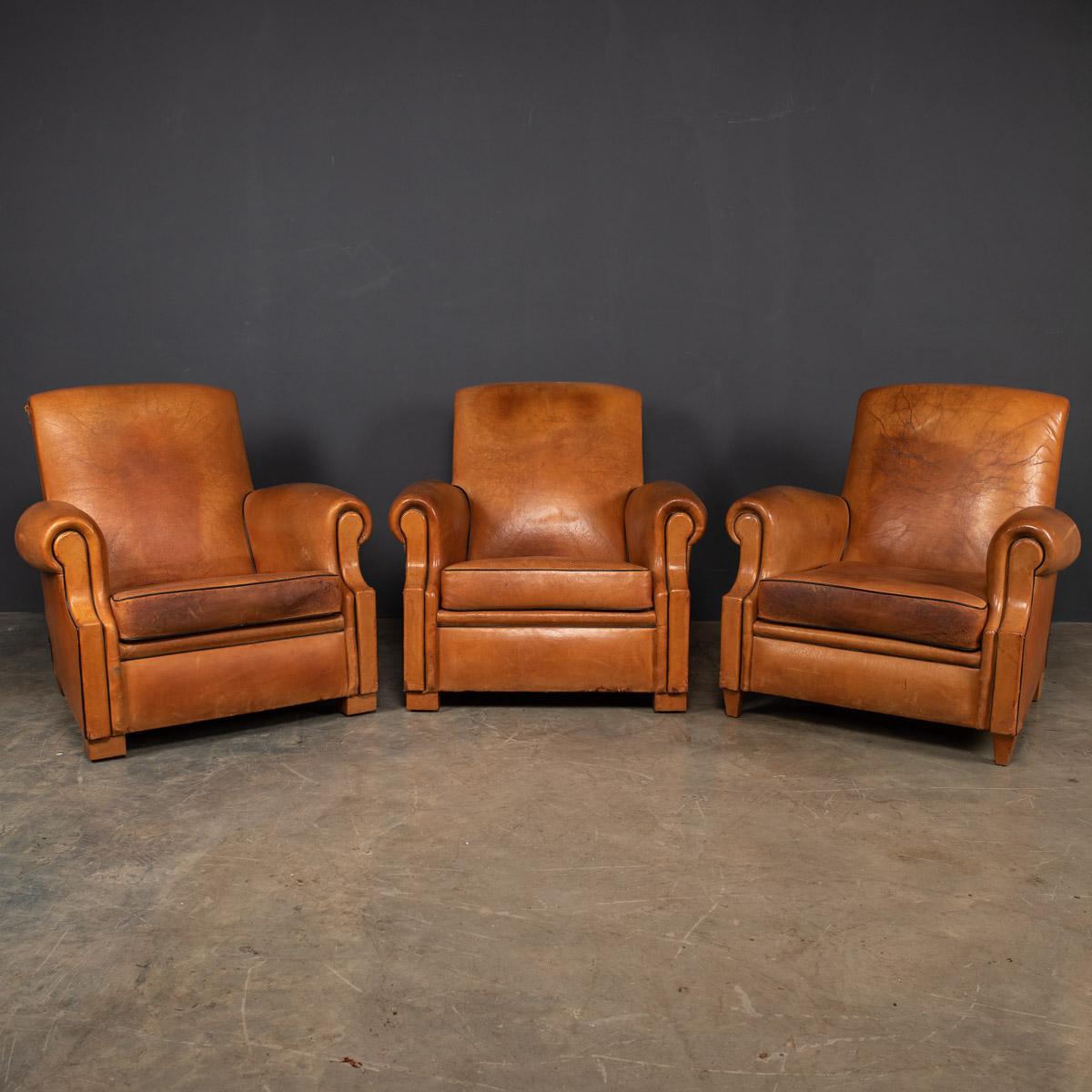 Superb 20th century French set of three club chairs, showing superb patina and colour, this wonderful set of club chairs were hand upholstered tan sheepskin leather and with original black piping to the front. Made in France by the finest craftsmen.