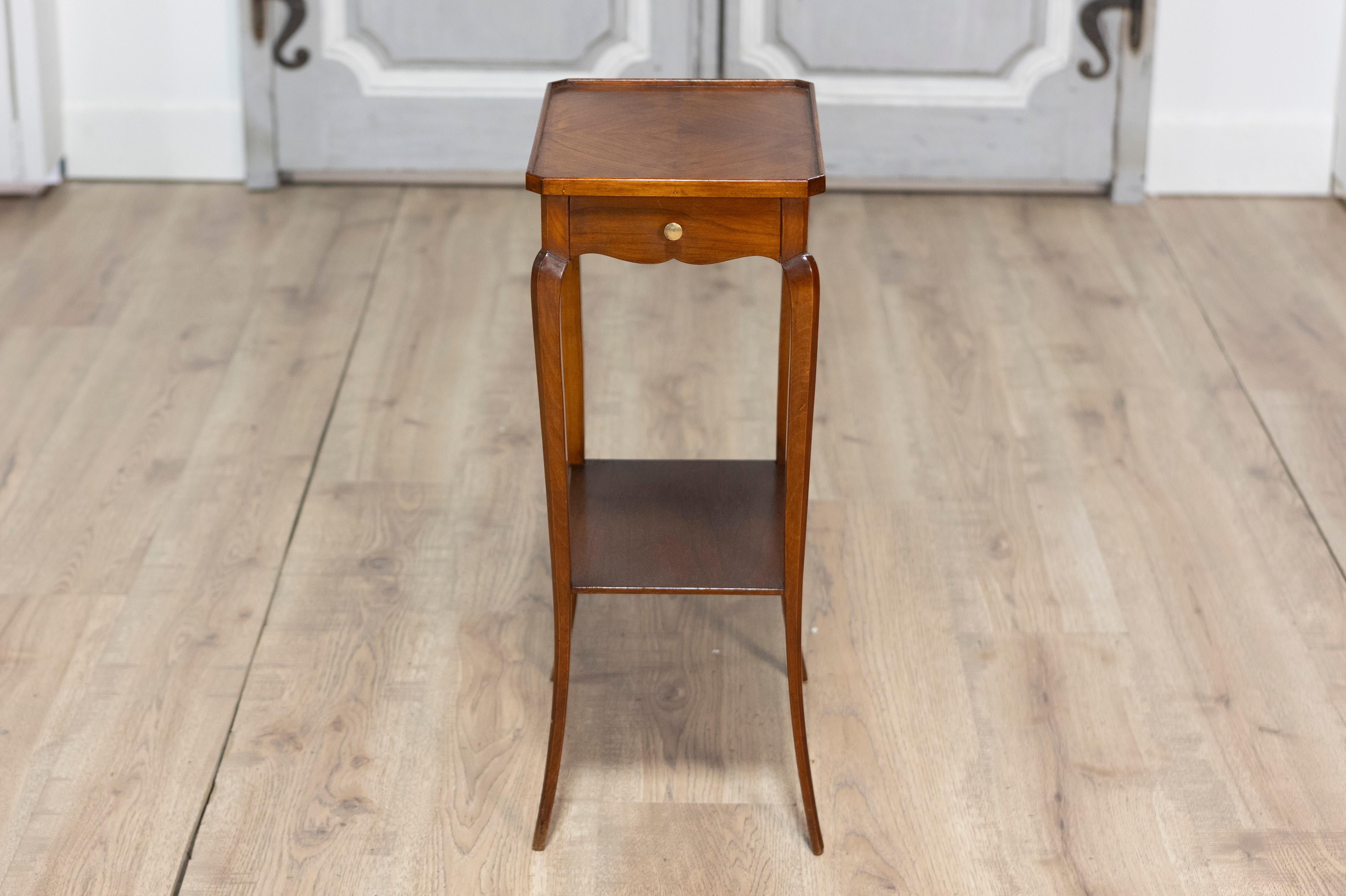 Cette charmante petite table d'appoint de style Louis XV du XXe siècle allie élégance et fonctionnalité. La table s'ouvre sur un tiroir de chaque côté, offrant un rangement pratique. Il repose gracieusement sur quatre pieds arqués, qui sont reliés
