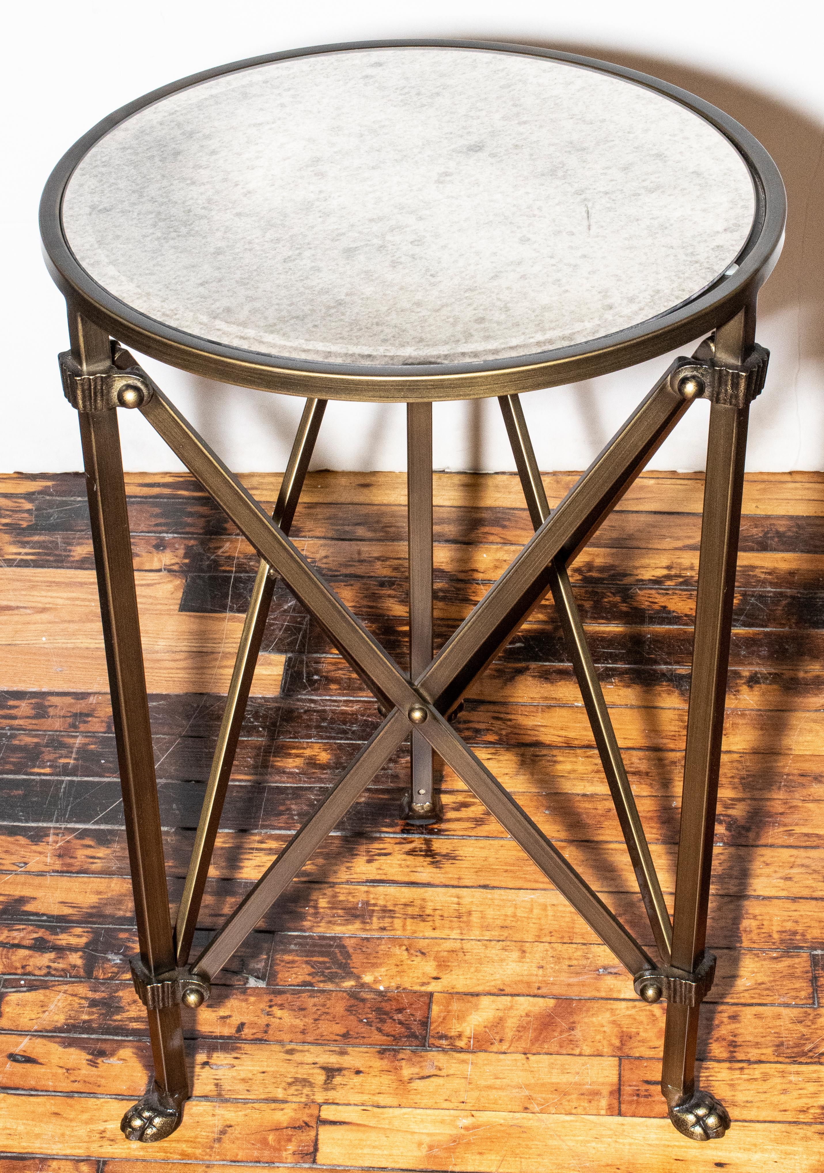20th century French side table with brass base and round mirrored top. Paw feet detail on base.