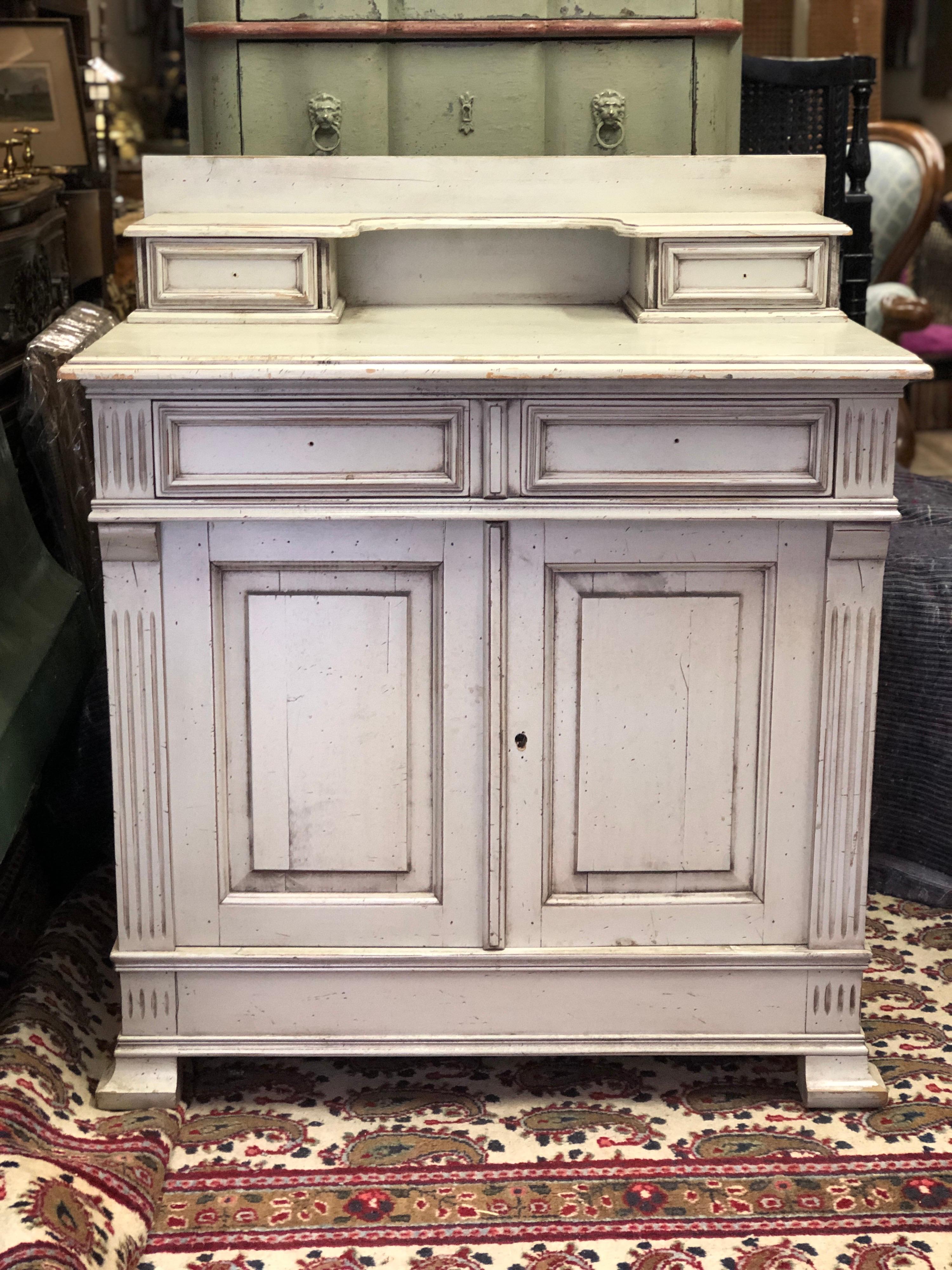French hand carved sideboard in natural wood painted in light green, opening by two doors and four drawers, the sides are decorated with grooves. Perfect for installing a sink for a vintage bathroom.
France, circa 1920.