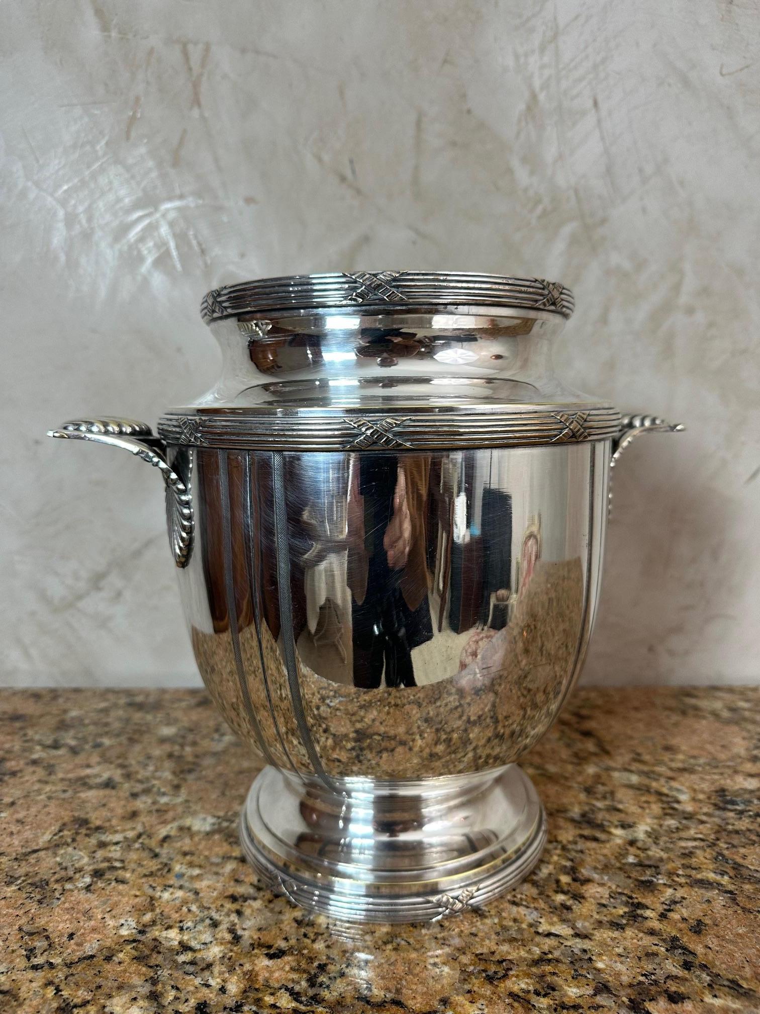 Superbe seau à champagne datant des années 1930, réalisé en métal argenté.
Son design raffiné aux lignes épurées et équilibrées est rehaussé par de délicats détails gravés et des poignées latérales finement travaillées.

Ce modèle incarne l'élégance
