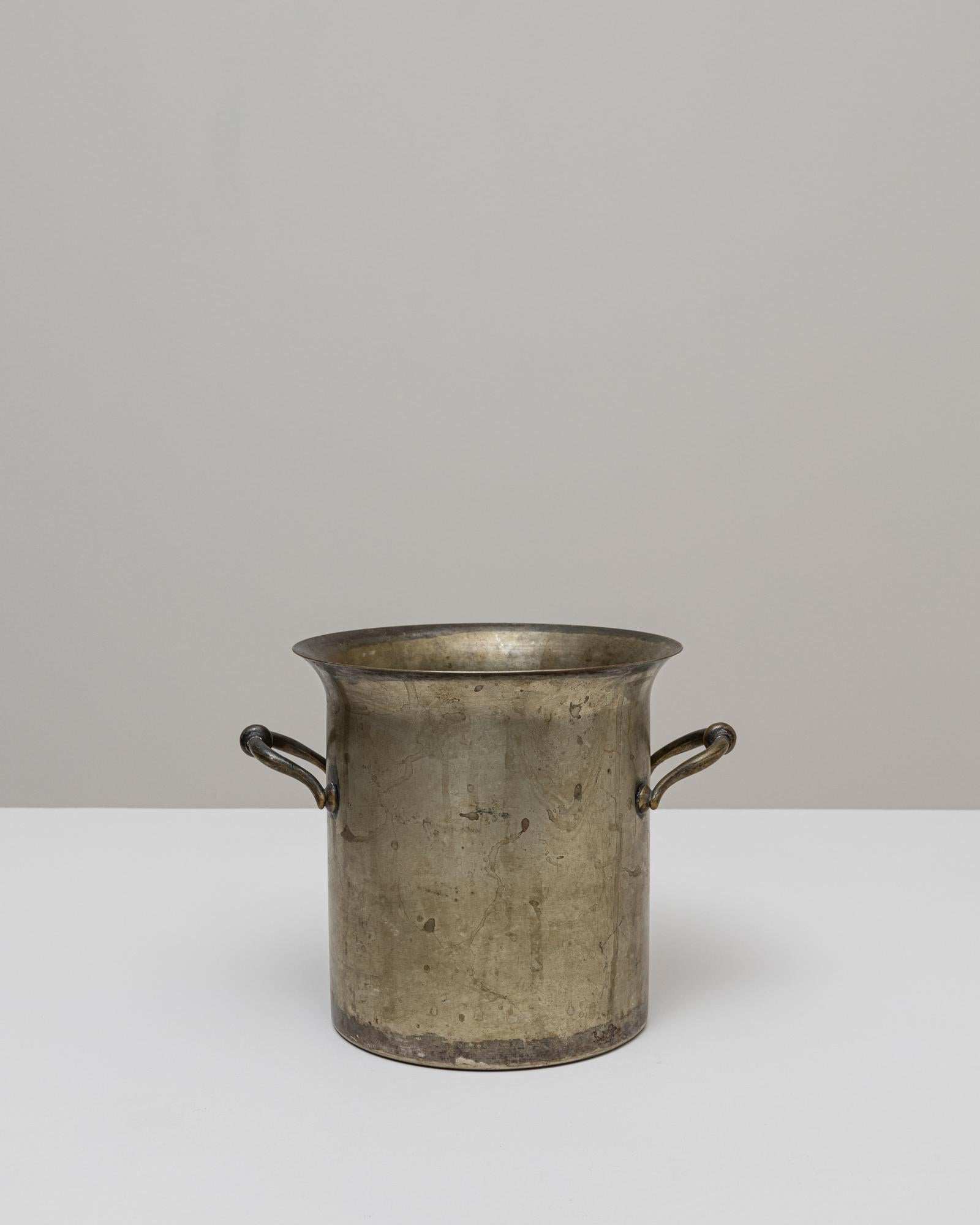 Seau à champagne en métal argenté français du 20e siècle, dont la forme cylindrique droite est adoucie par un bord subtilement évasé. La simplicité de sa silhouette met en valeur l'élégance utilitaire que l'on retrouve souvent dans les pièces