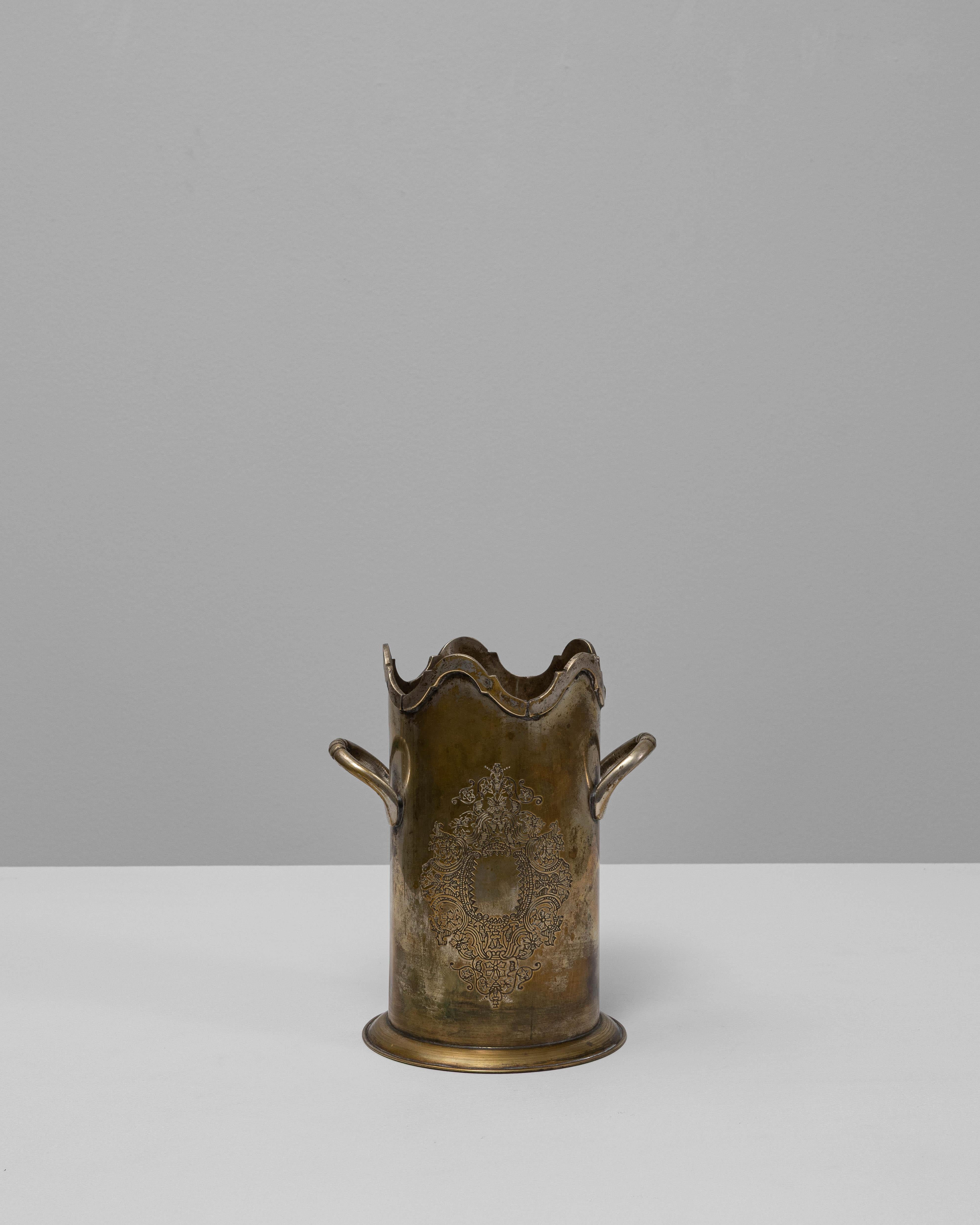 Dieser französische, versilberte Eiskübel aus dem 20. Jahrhundert zeigt die raffinierte Handwerkskunst und den dekorativen Sinn für Design aus der Zeit um 1900. Die zylindrische Form wird durch zart geschwungene Griffe und einen geschwungenen Rand