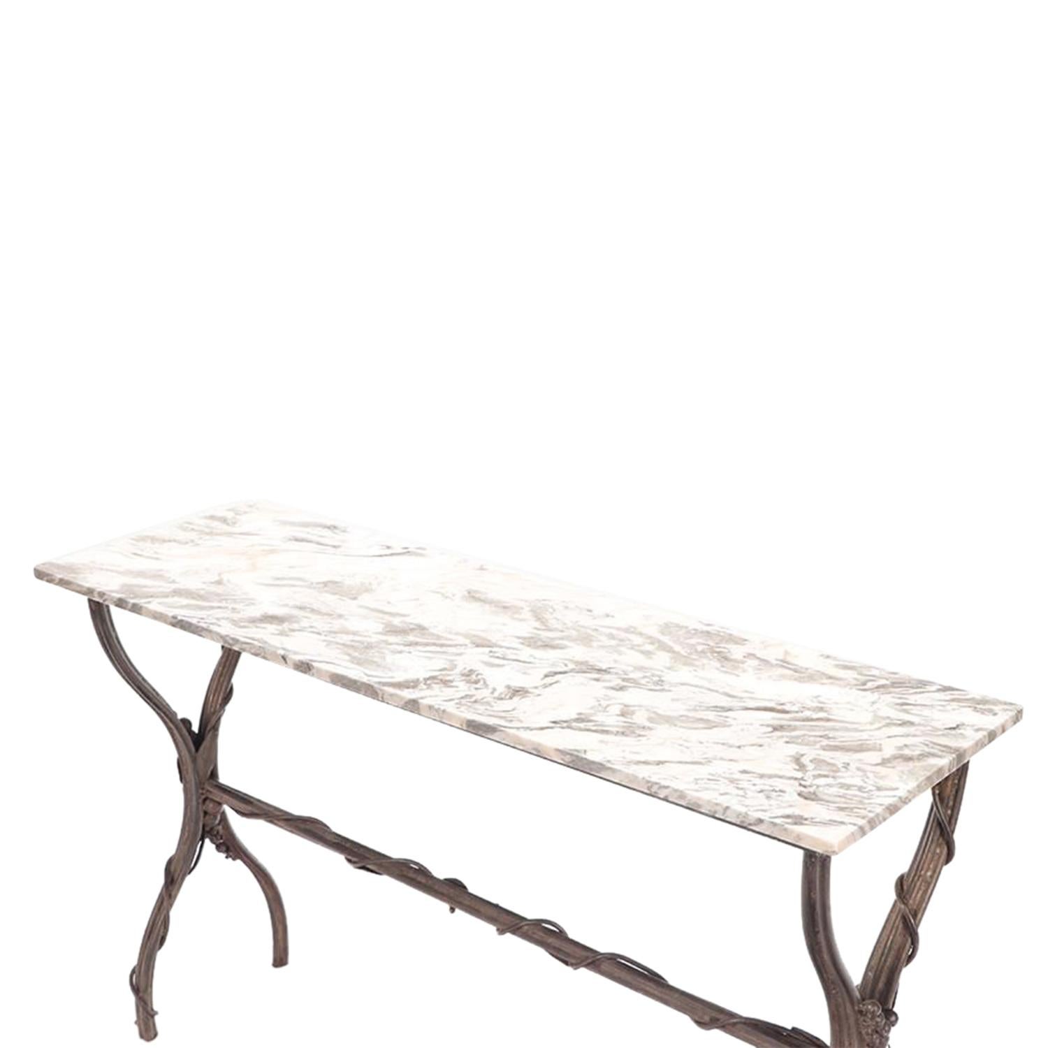 
A vintage Mid-Century modern French freestanding console table made of hand crafted iron attributed to Diego Giacometti, in good condition. The rectangular end table is composed with a white-grey marble top, standing on four arched legs which is
