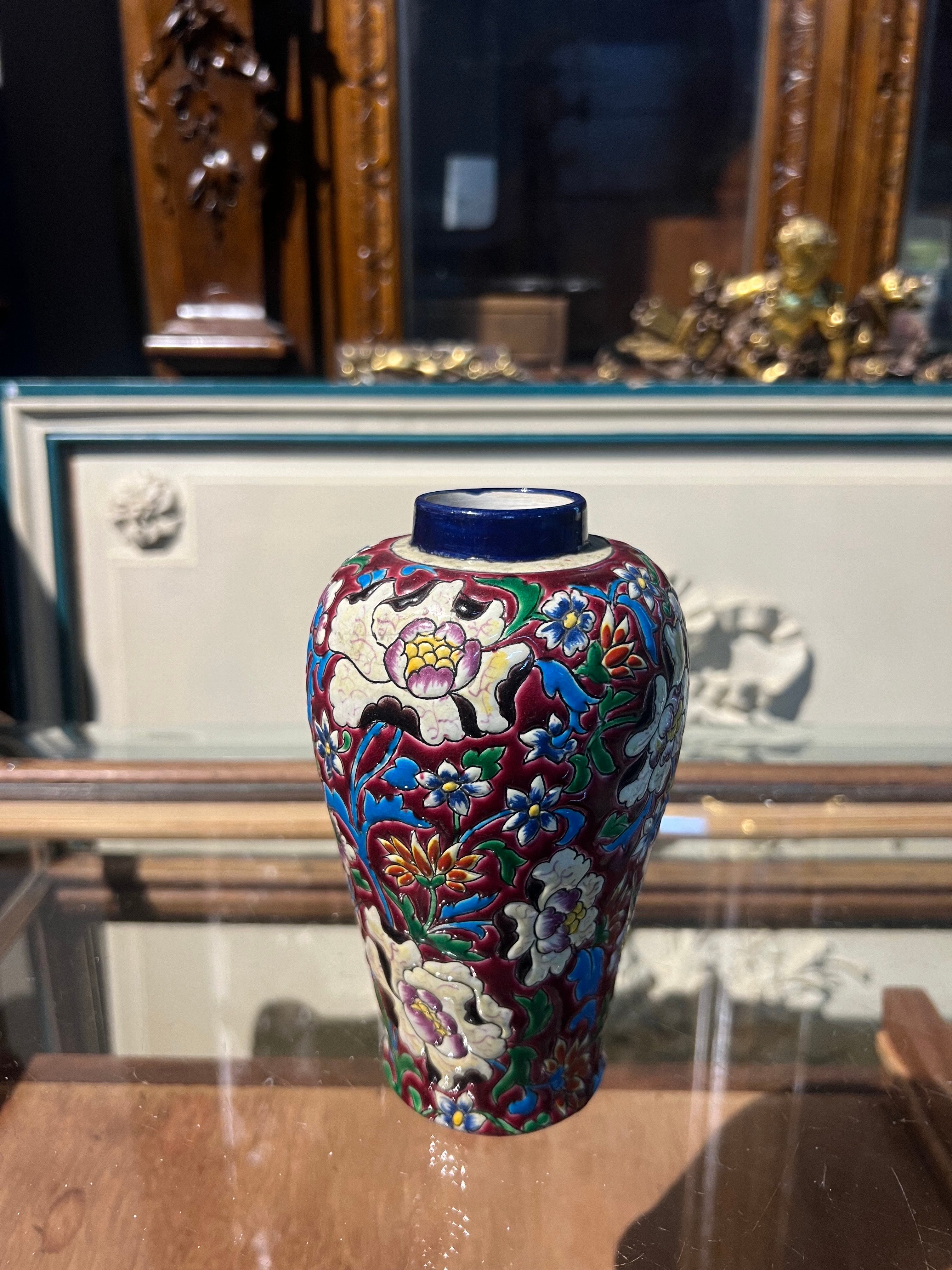 Kleine französische handgefertigte und handkolorierte Vase von Longwy. Sehr guter authentischer Zustand und sehr leuchtende Farben, verziert mit vielen schönen Blumen. 
Frankreich, um 1930