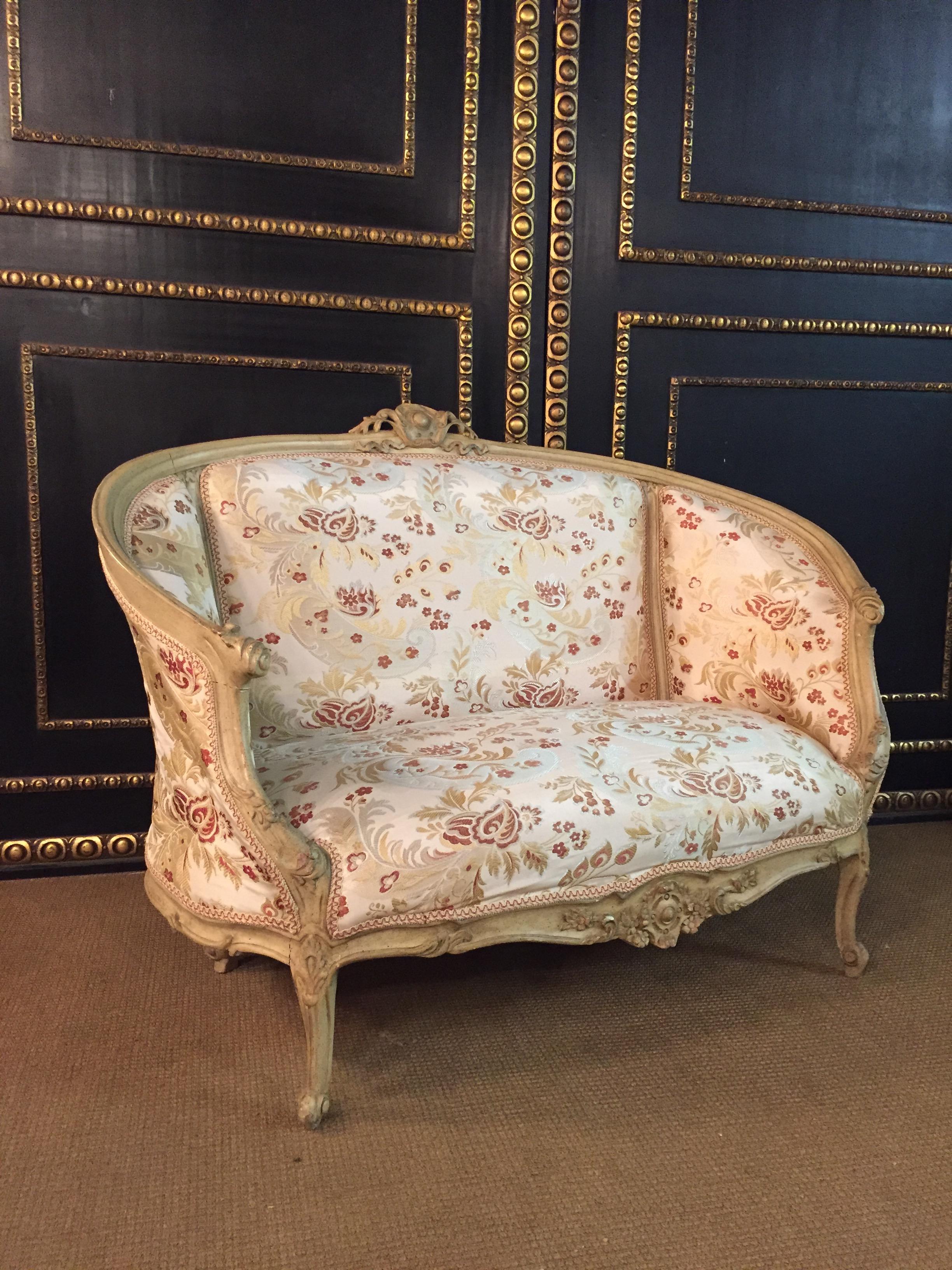 Solid beechwood, carved, colored and gilded. Semicircular ascending backrest frame with perforated rocaille crowning. Passive curved frame with richly reifiert carved leaf. Slightly bent frame on curly legs. The seat and backrest are finished with a