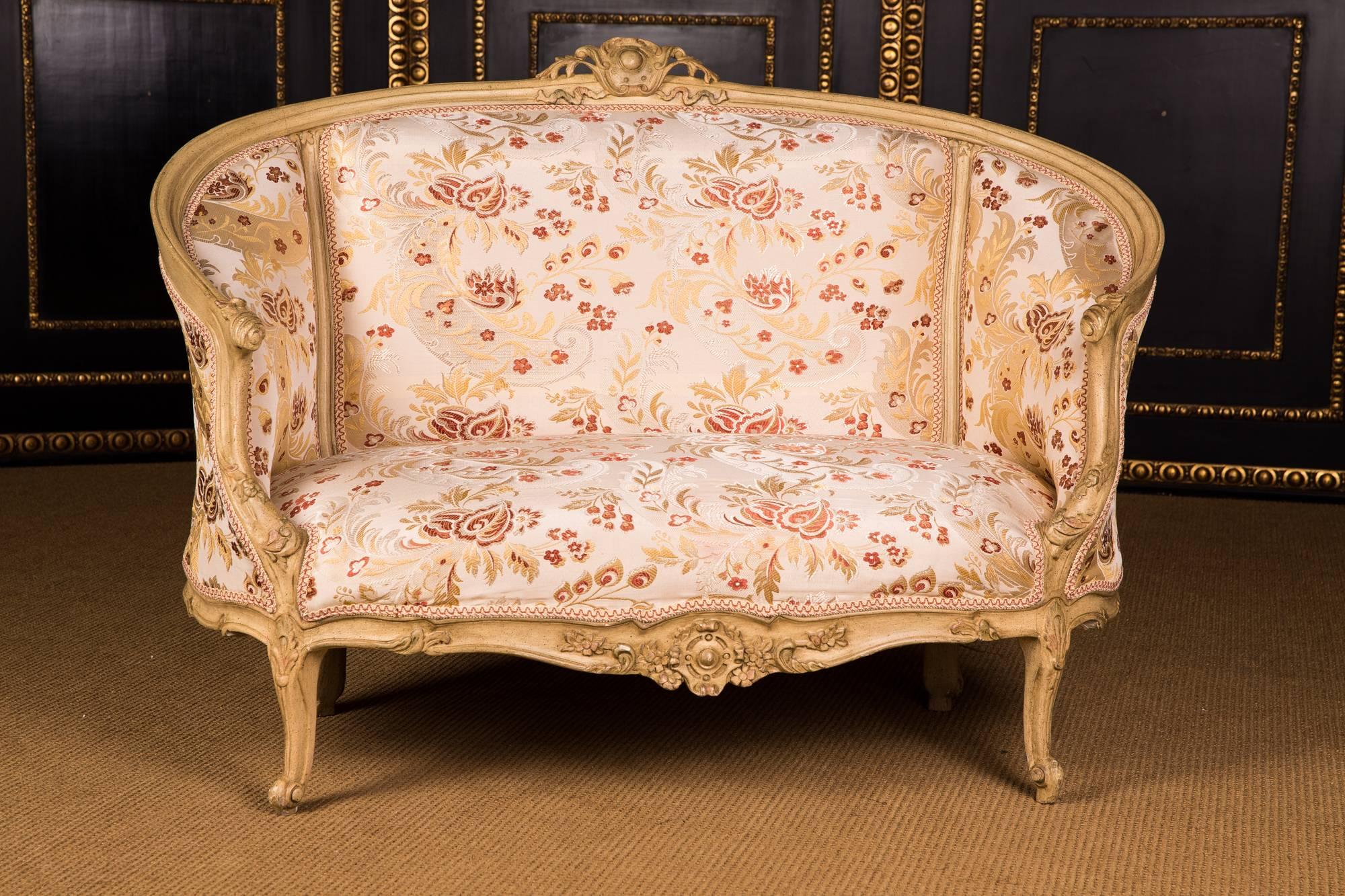 Solid beechwood, carved, colored and gilded. Semicircular ascending backrest frame with perforated rocaille crowning. Passive curved frame with richly reifiert carved leaf. Slightly bent frame on curly legs.
The seat and backrest are finished with
