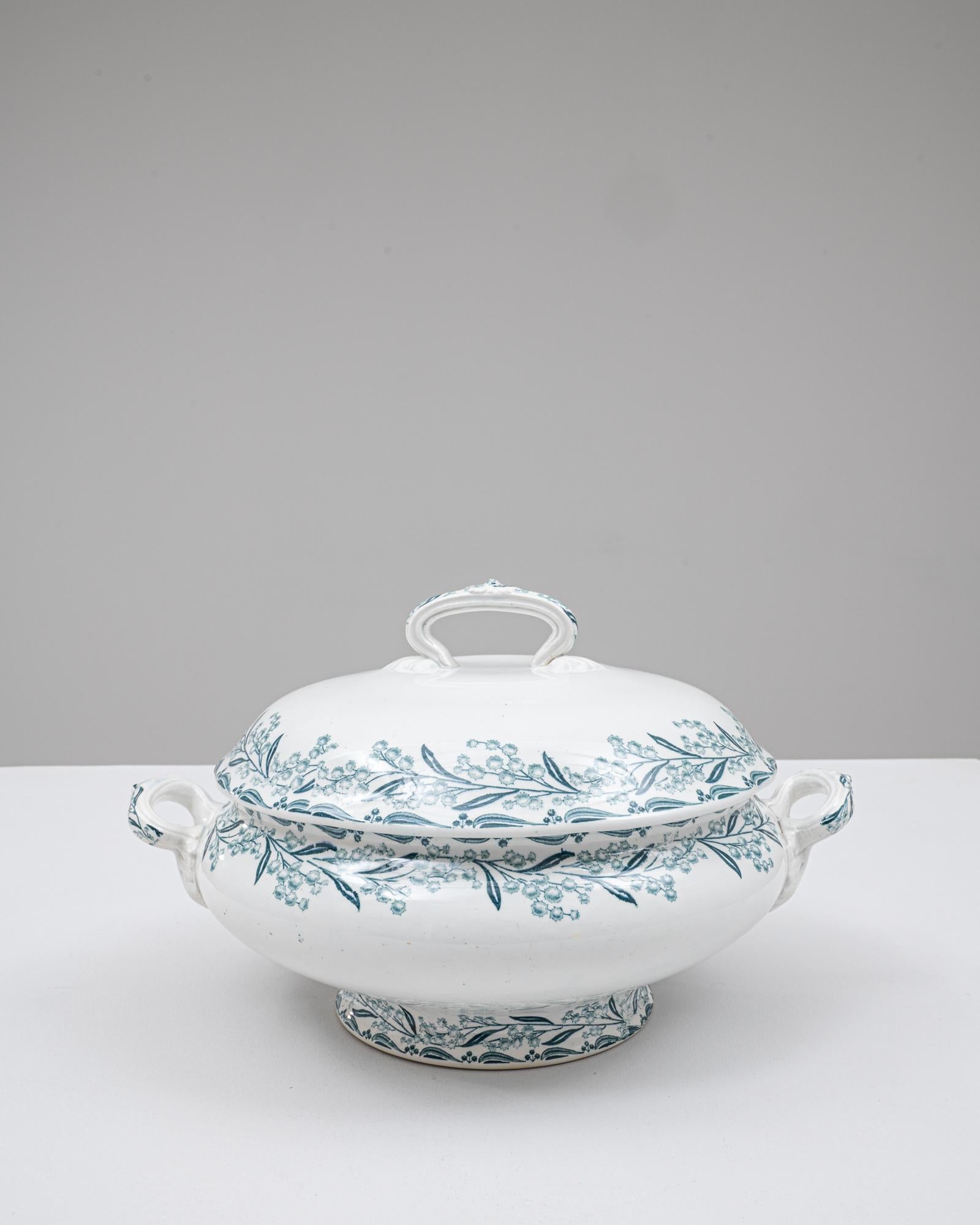 Cette soupière en porcelaine française du 20e siècle, édition spéciale, présente une élégante silhouette arrondie décorée d'une bande continue de délicats motifs floraux sarcelle. Le couvercle bombé présente une poignée en boucle sculptée avec des