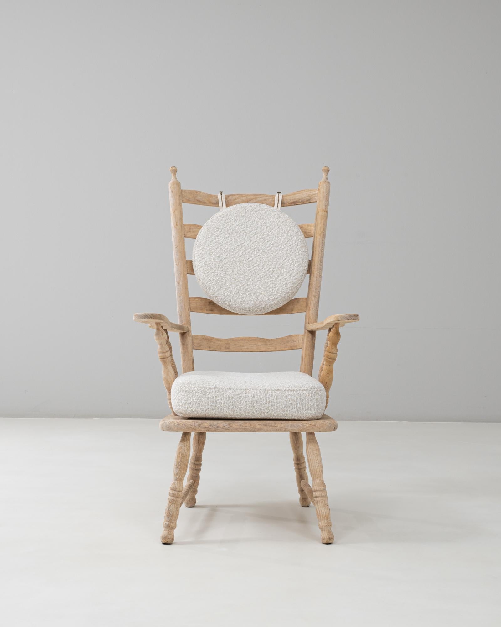 This 20th Century French Spindle-Back Oak Armchair with Bouclé Cushions exemplifies rustic refinement and modern comfort. Crafted from solid oak with a softly bleached finish, the chair features turned spindle detailing along the back, arms, and