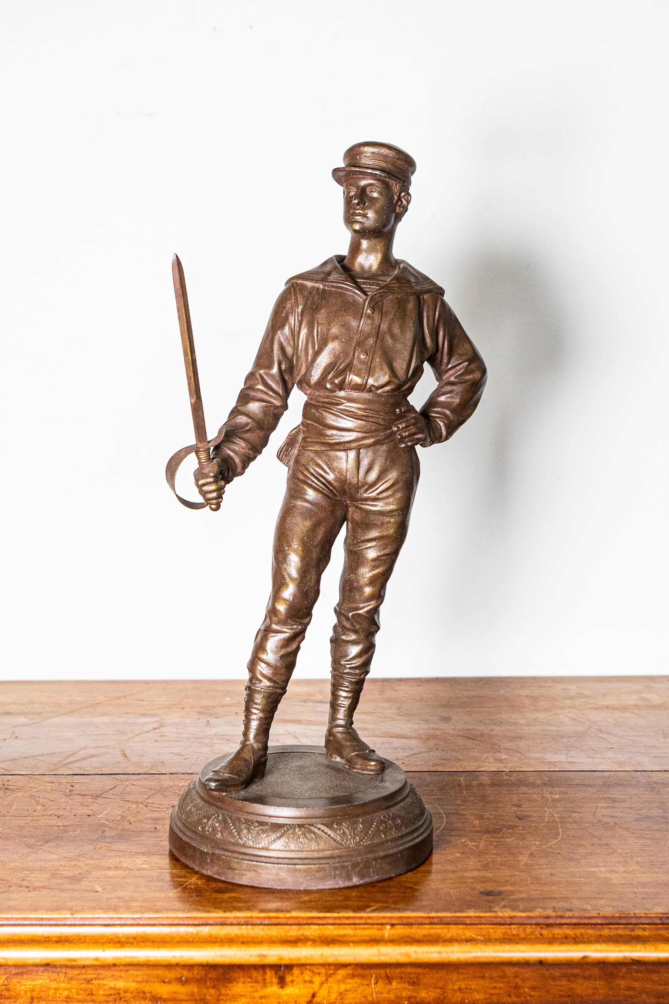 Questo trofeo in bronzo francese dell'inizio del XX secolo cattura magnificamente l'eleganza e l'atletismo della scherma, con un'impressionante figura di uno schermidore in piedi con la spada in mano. La scultura emana sicurezza e maestria, con