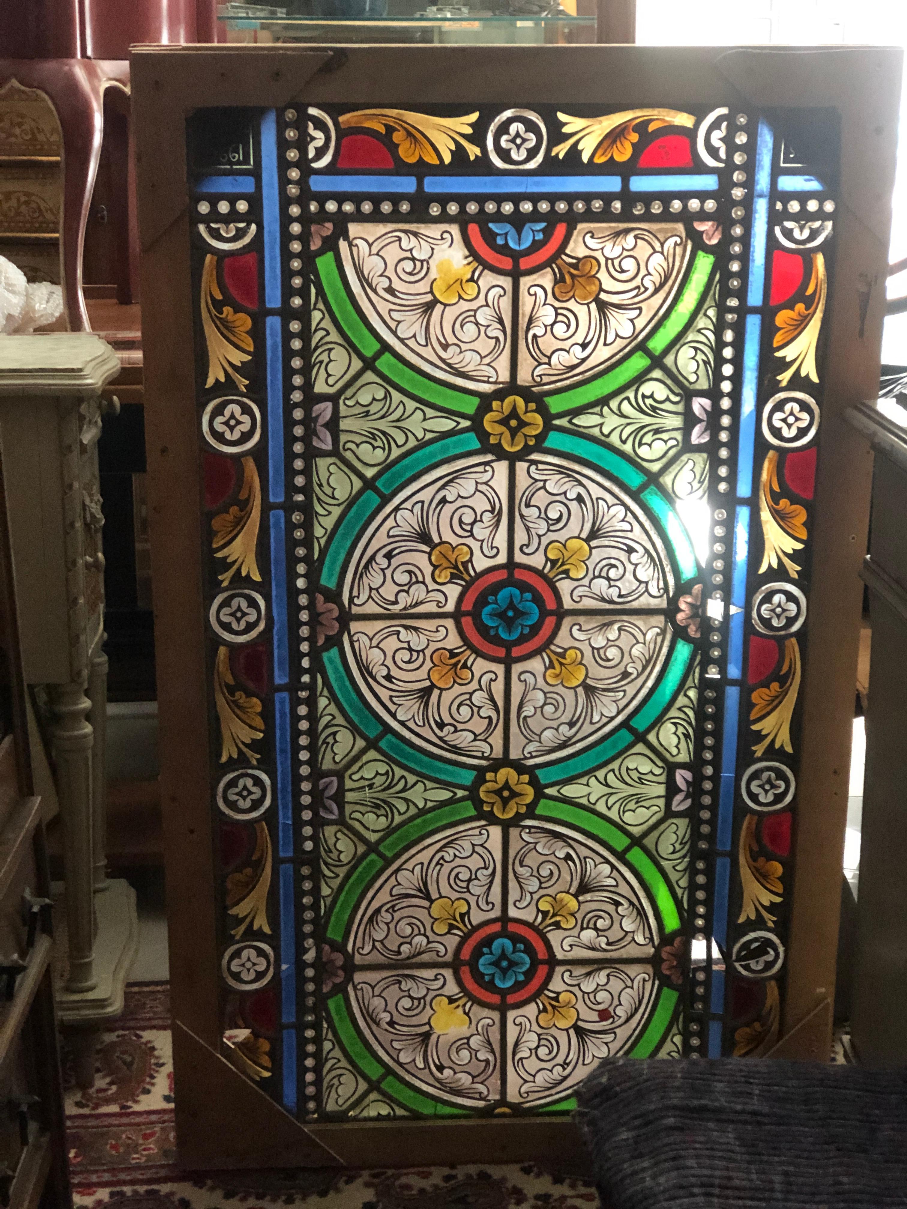 Magnifique panneau de vitrail multicolore avec une ornementation florale et géométrique détaillée. Il y a quelques petites pièces manquantes mais aucune restauration n'a été effectuée.
Il est placé dans un cadre en bois afin de rester en sécurité.