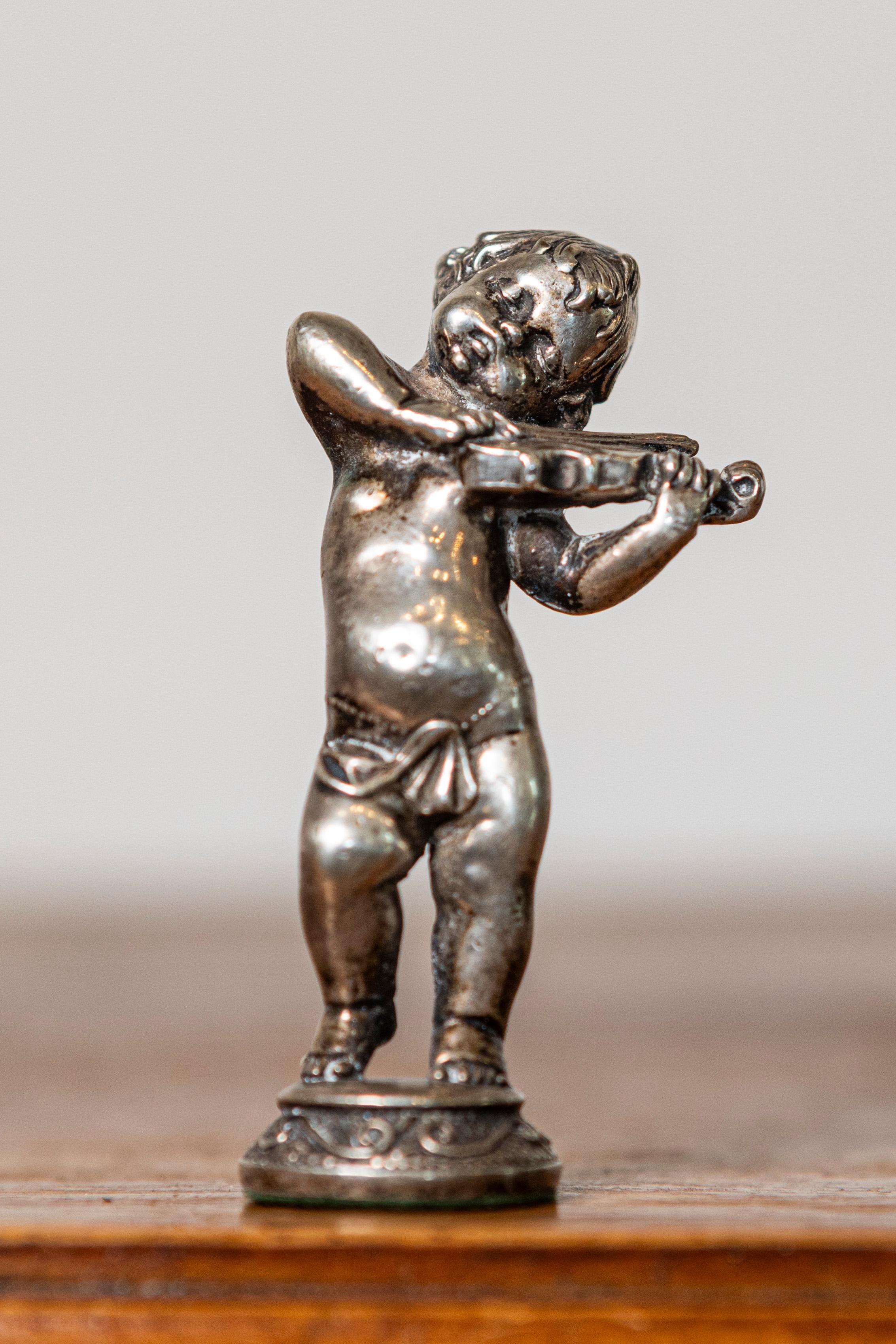 Questa affascinante statuetta in miniatura francese dell'inizio del XX secolo cattura la giocosa eleganza di una figura cherubica che suona gioiosamente il violino. Realizzato con un'attenzione meticolosa ai dettagli, il pezzo è realizzato in