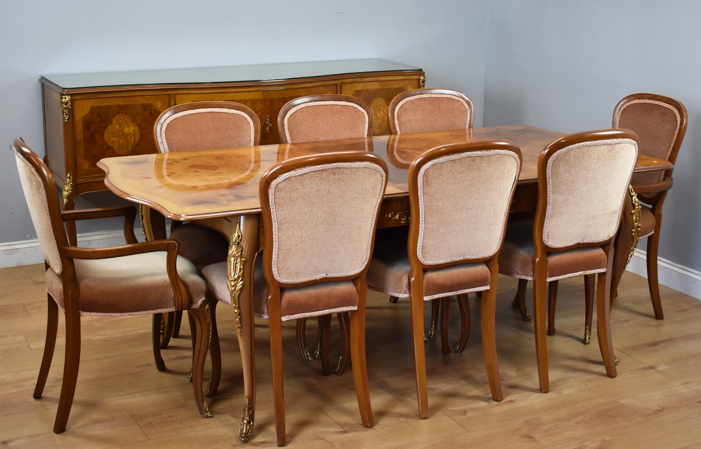 For sale is a good quality burr walnut dining suite by H&L Epstein. The suite comprises a large four door sideboard, 8 seat dining table and 8 dining chairs (two carvers + six singles). The sideboard is serpentine in form and has four cupboard