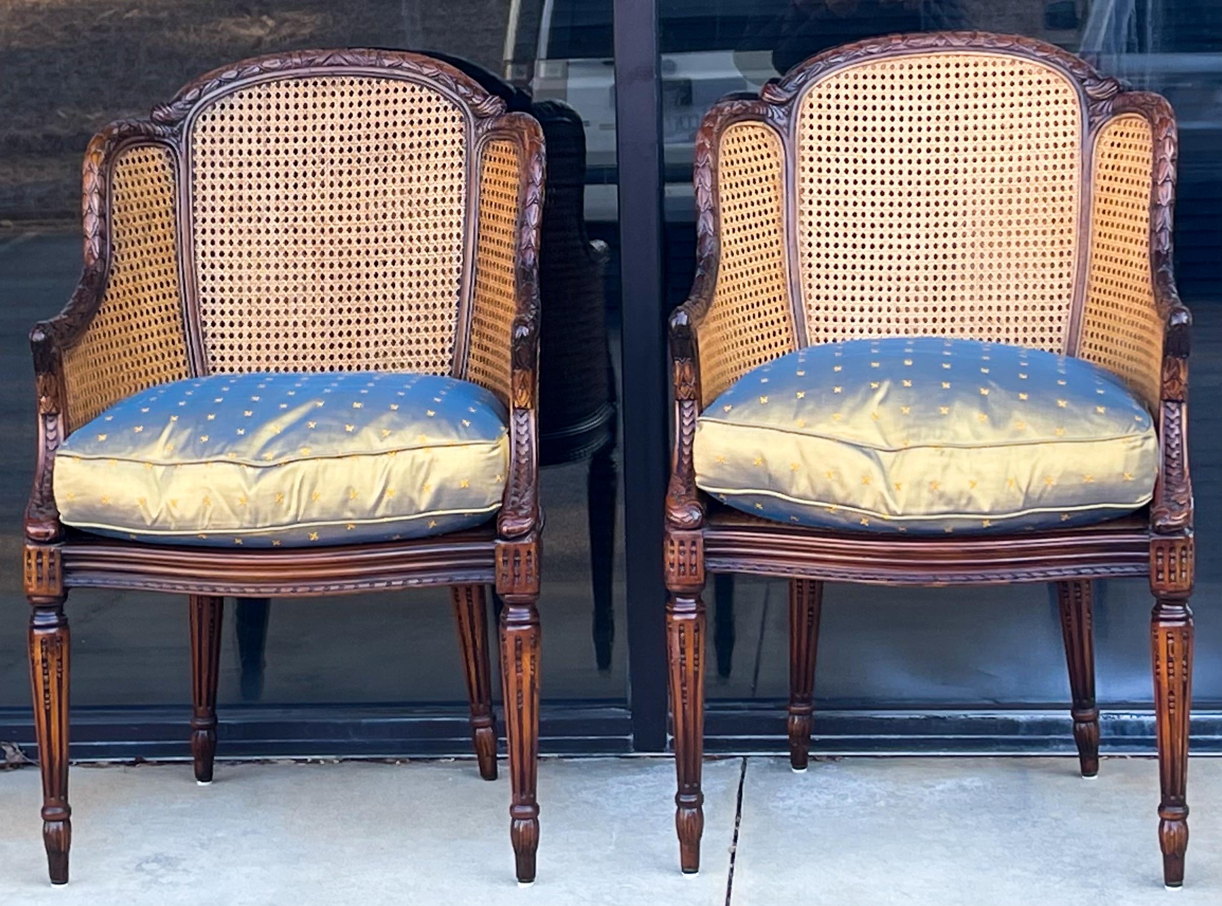 These lovely double cane French style chairs are by Maitland-Smith. The are in very good condition and have a loose down cushion wrapped in embroidered silk. They are marked. There is one mark on one cushion but the opposite side is fine. The carved