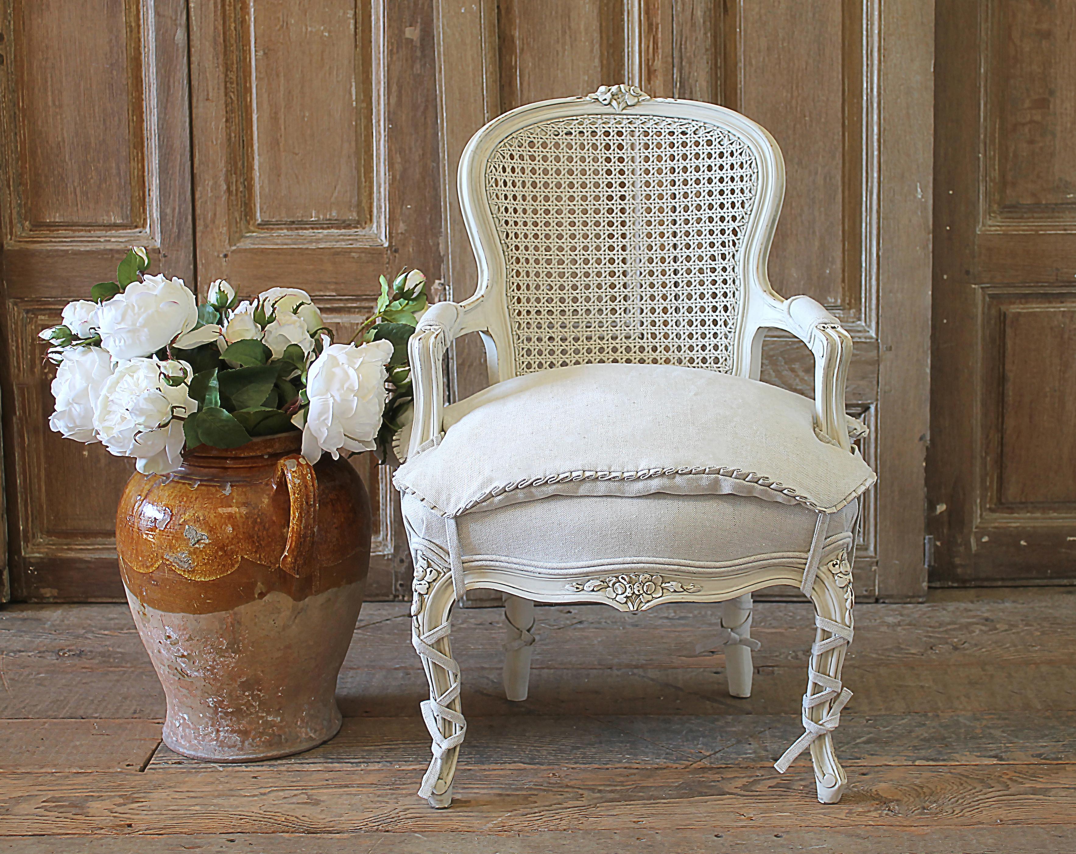 20th century French style Louis XV cane back childs chair. Beautifully painted chair in our oyster white finish, with subtle distressed edges, and finished with an antique glazed patina. Classic Louis XV Style. Reupholstered in a Greige colored