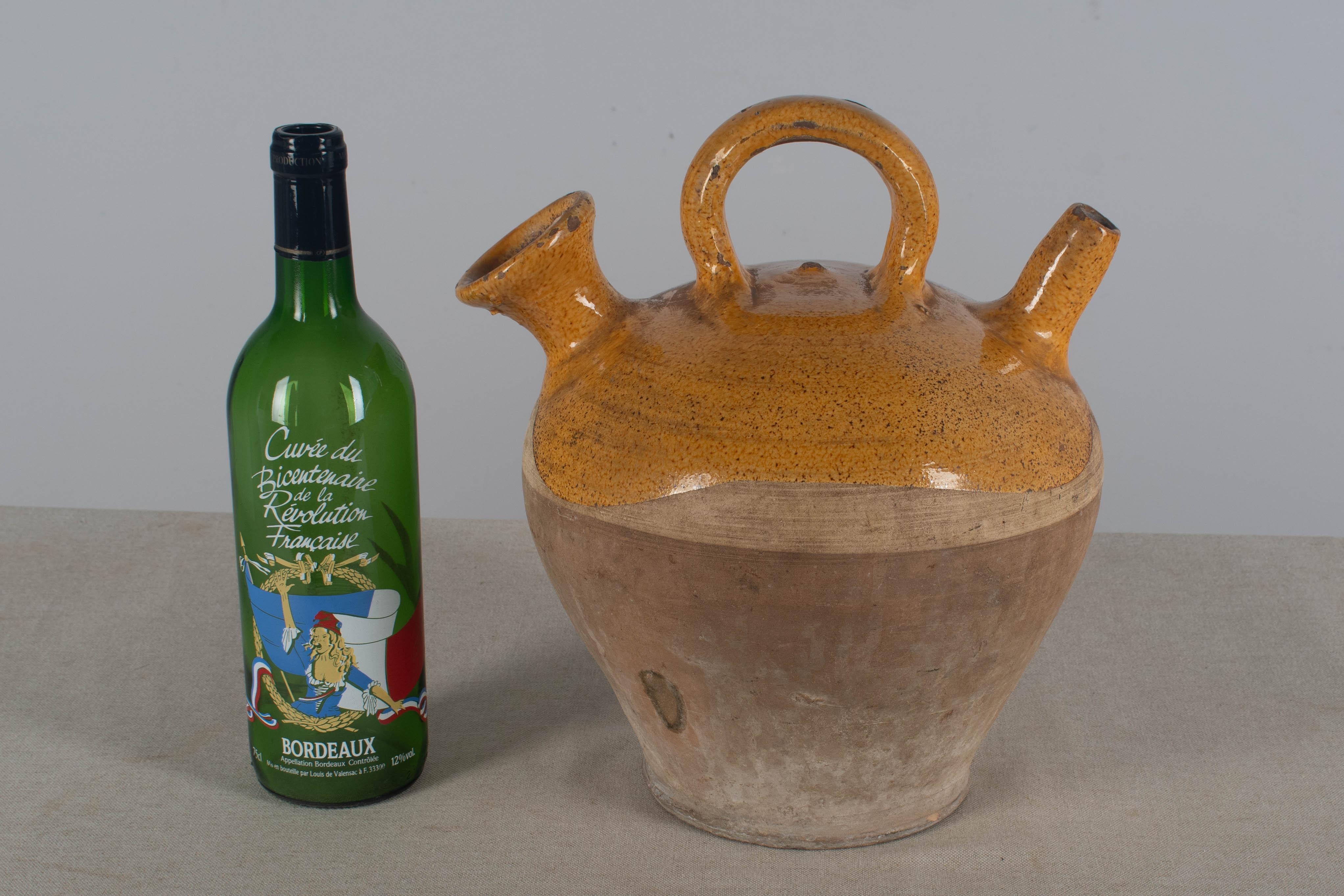 A 20th  century terracotta vinaigrier, or vinegar pot, from the Southwest of France with traditional yellow glaze. In good condition with nice patina. A few small chips to the glaze. We have a large collection of French pottery in green, yellow and