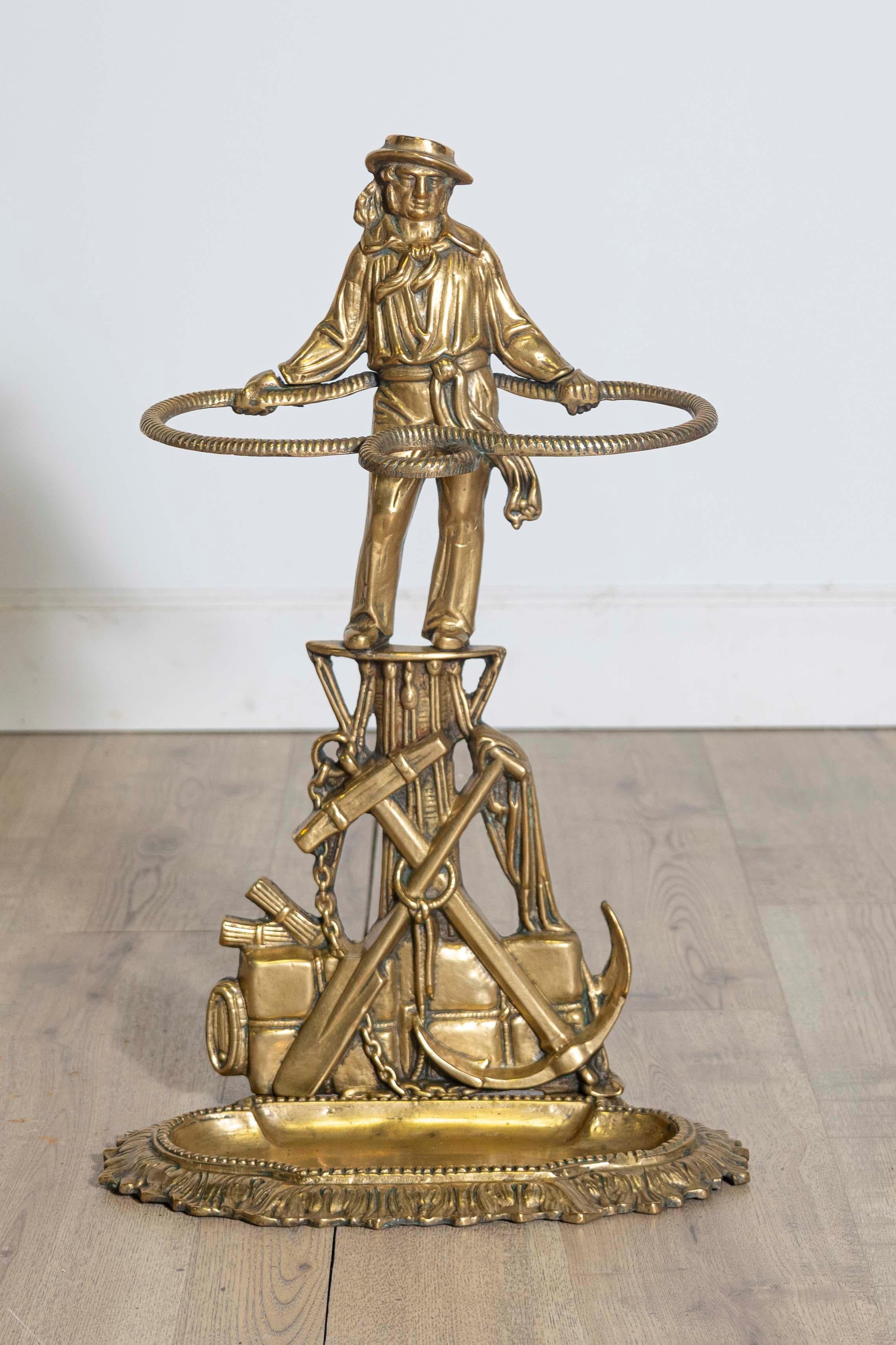 This charming 20th century French umbrella stand is both decorative and functional. Crafted from gilt bronze, it showcases a whimsical design featuring a sailor figure surrounded by nautical elements, such as an anchor and detailed rope