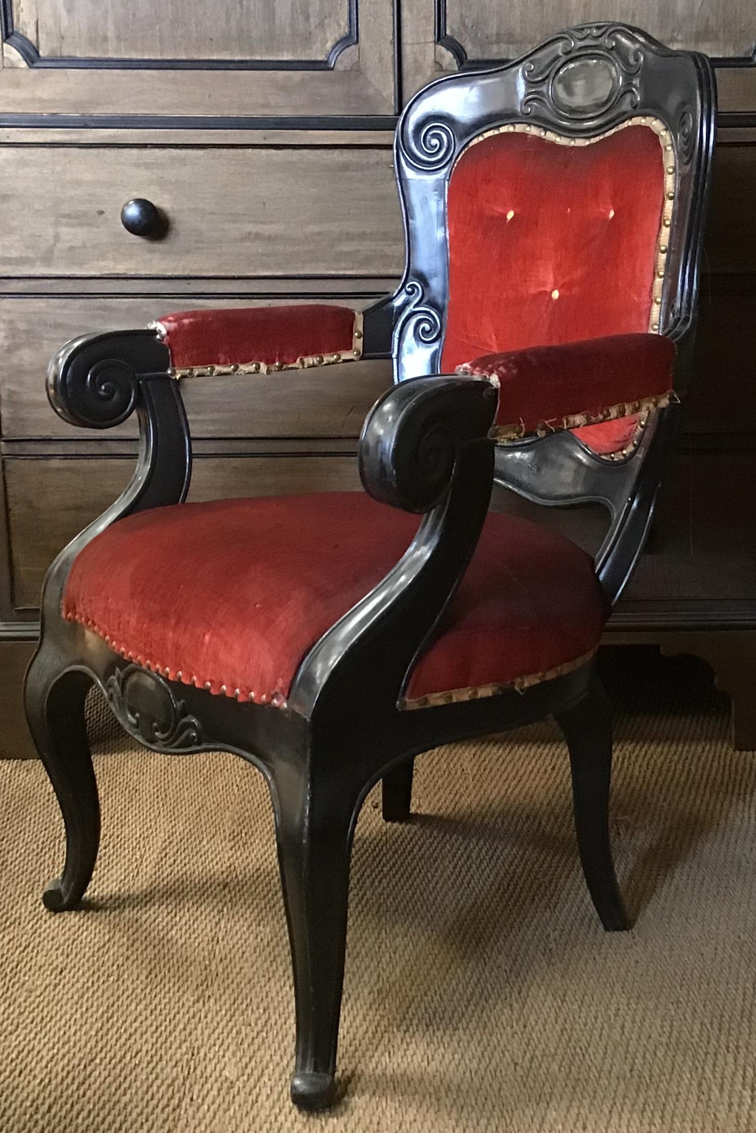 20th century French upholstered armchair in carved ebonized wood from 1920.