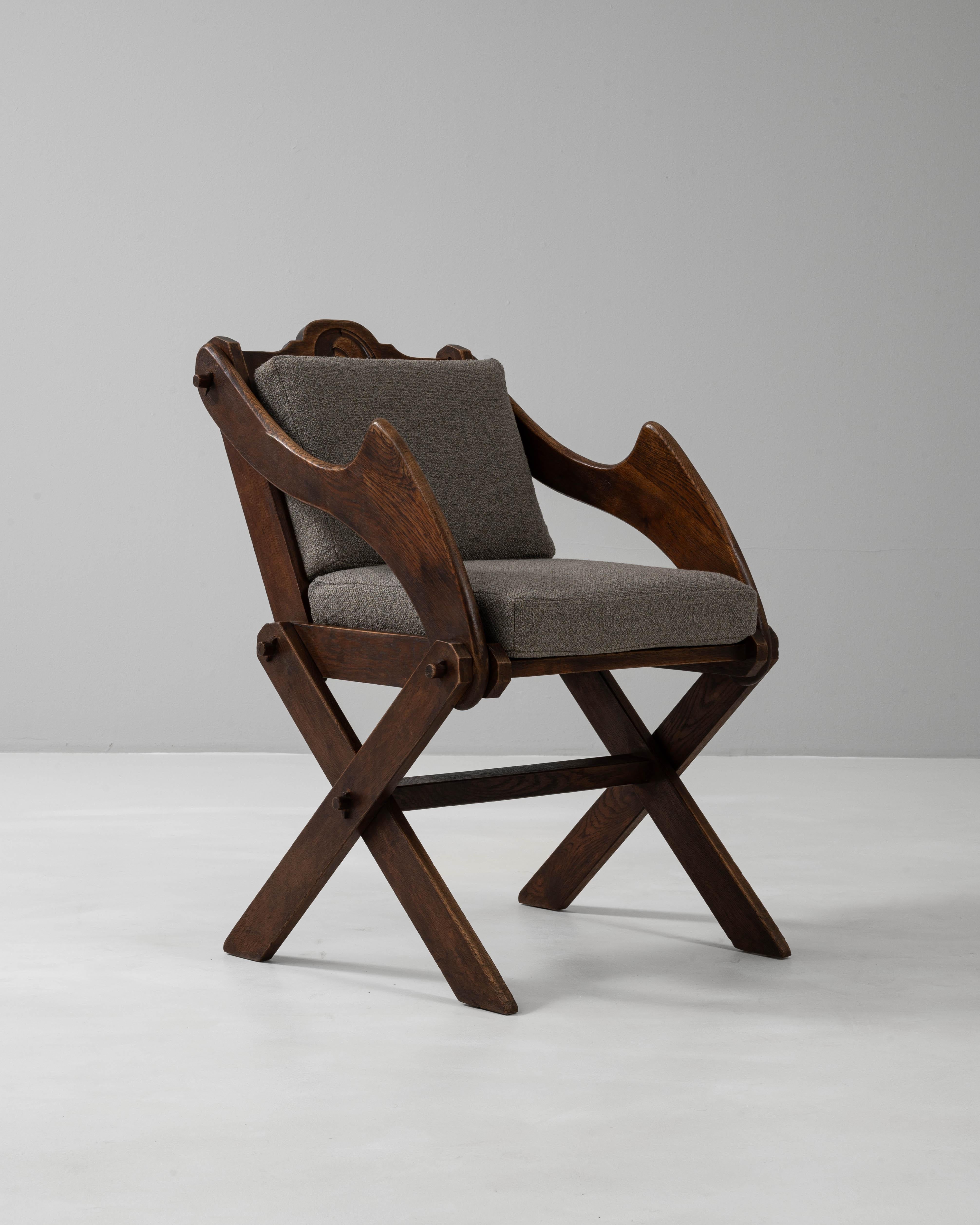 Cette chaise Glastonbury française du XXe siècle, tapissée et conservée dans sa patine d'origine, reflète un design enraciné dans l'inspiration médiévale avec une interprétation française moderne. Le cadre en bois massif présente les pieds en X et