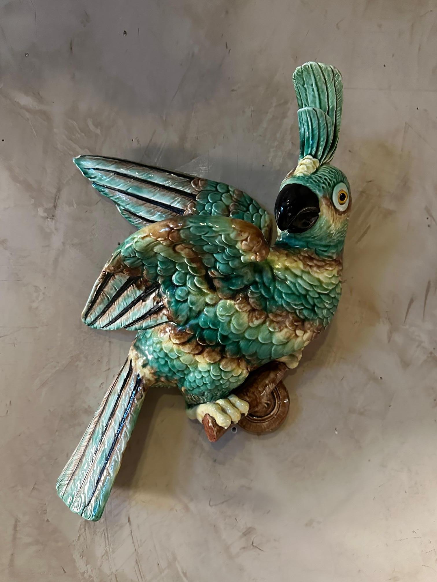 Magnificent ceramic parrot from Vallauris from the 50s with beautiful green and brown colors. A very small chip at the end of the left wing but very good general condition. A hole in the center to put flowers. 
To be placed on the wall as a