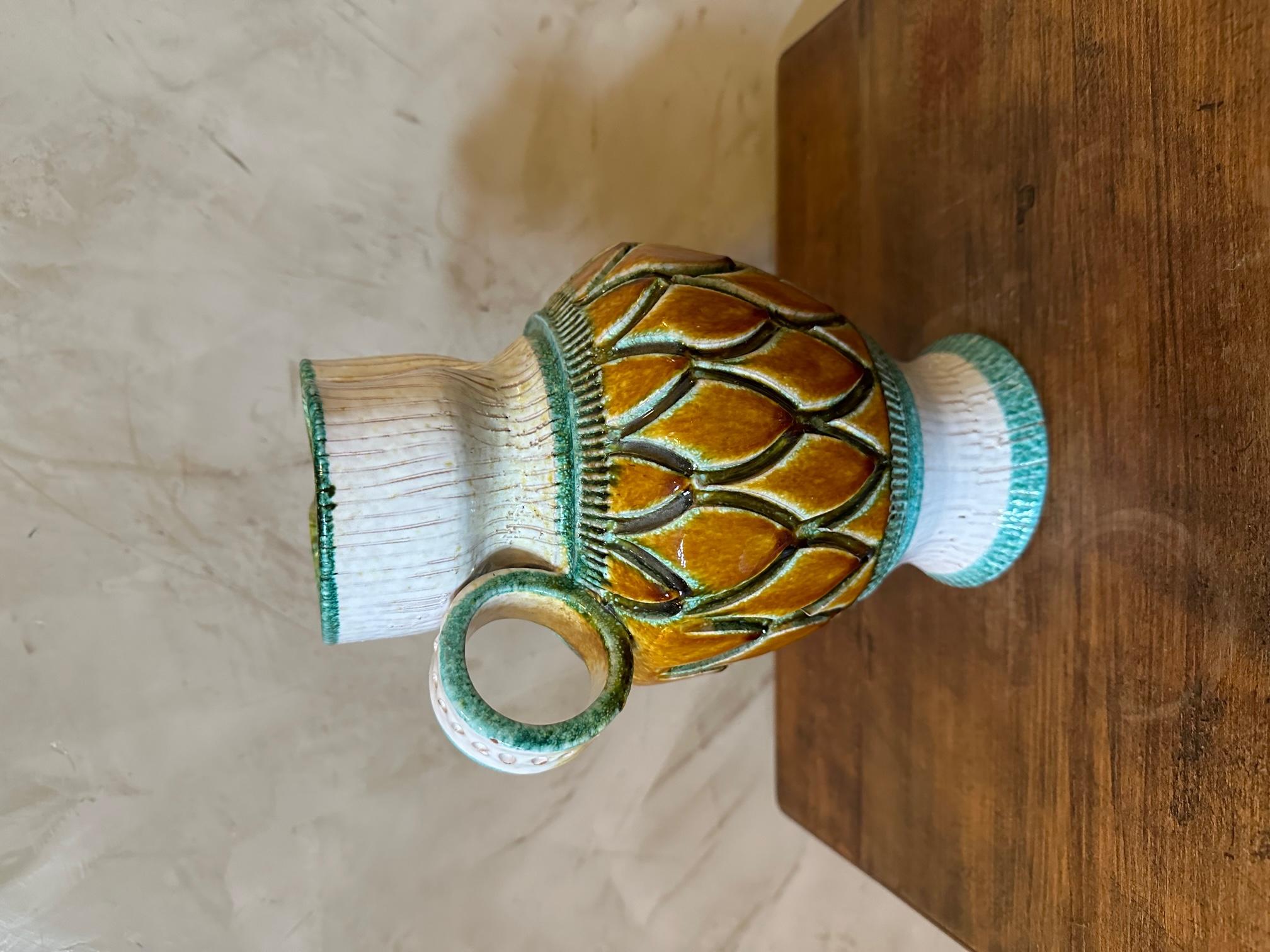 Very beautiful Vallauris ceramic pitcher from the 1950s in very good condition.
Pineapple skin patterns on the trunk and a crumpled shape at the beak. 
Beautiful ceramic work. Yellow, white and green color.
Round handle. Very nice quality.