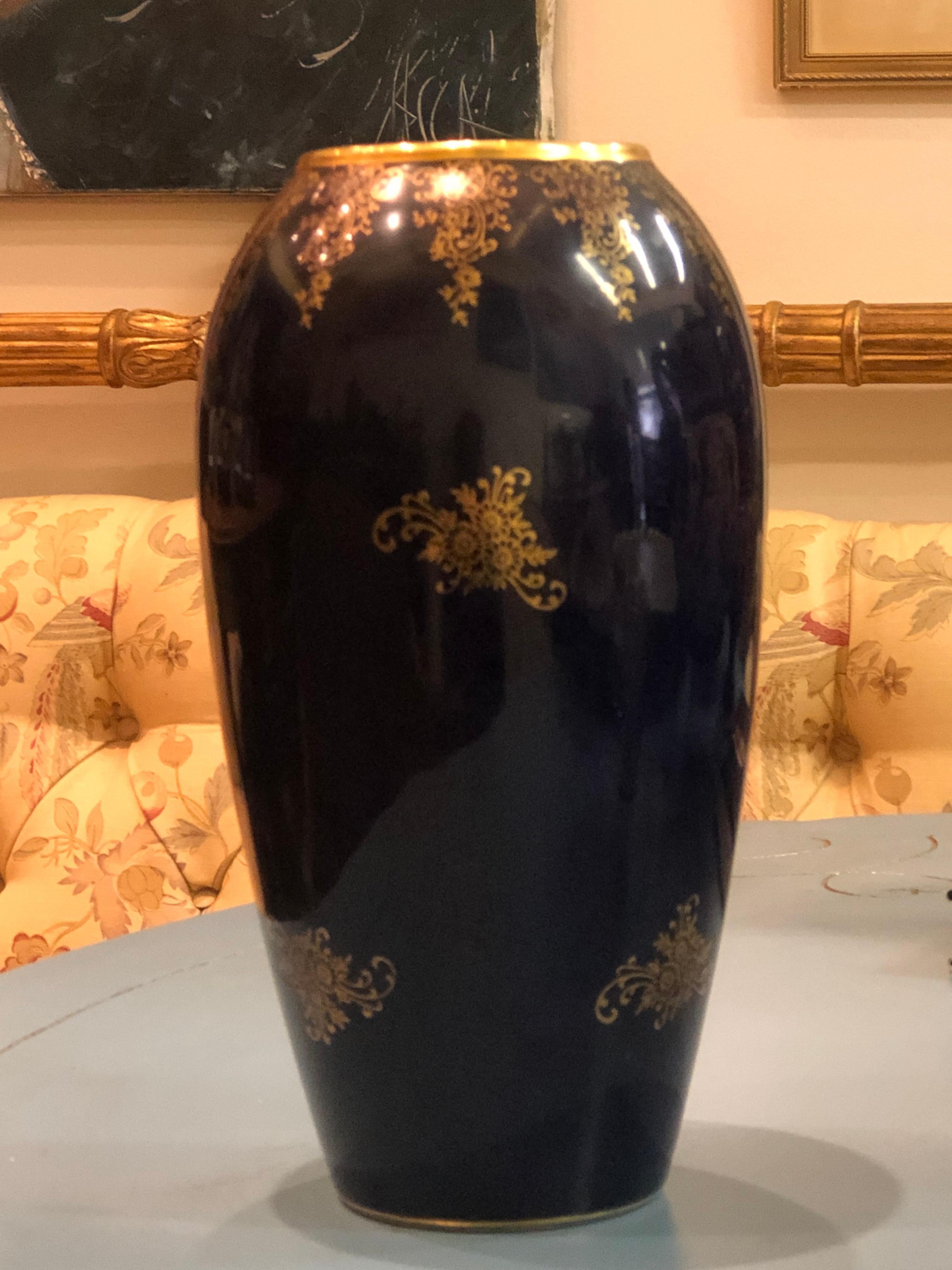 Beautiful dark blue vase decorated with floral elements surrounding a scene of a young couple having a secret love meeting.
France, circa 1920.