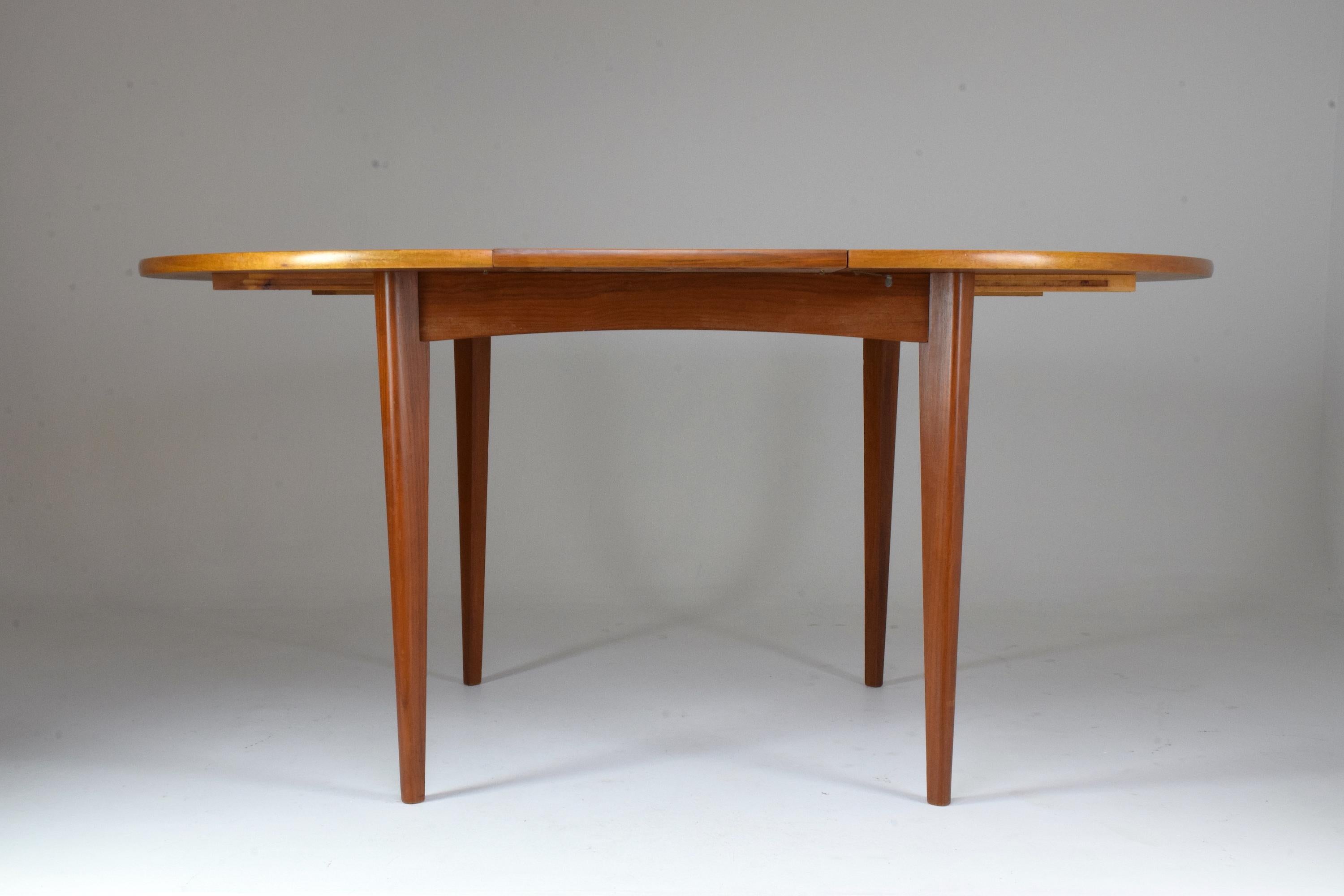 A Mid-Century Modern adjustable circular re-finished dining table of simple yet sophisticated Scandinavian style in solid teak sitting on tapered legs and fully functioning extensions. Fits 4 to 6 people. Useful for dining areas.

All our pieces are