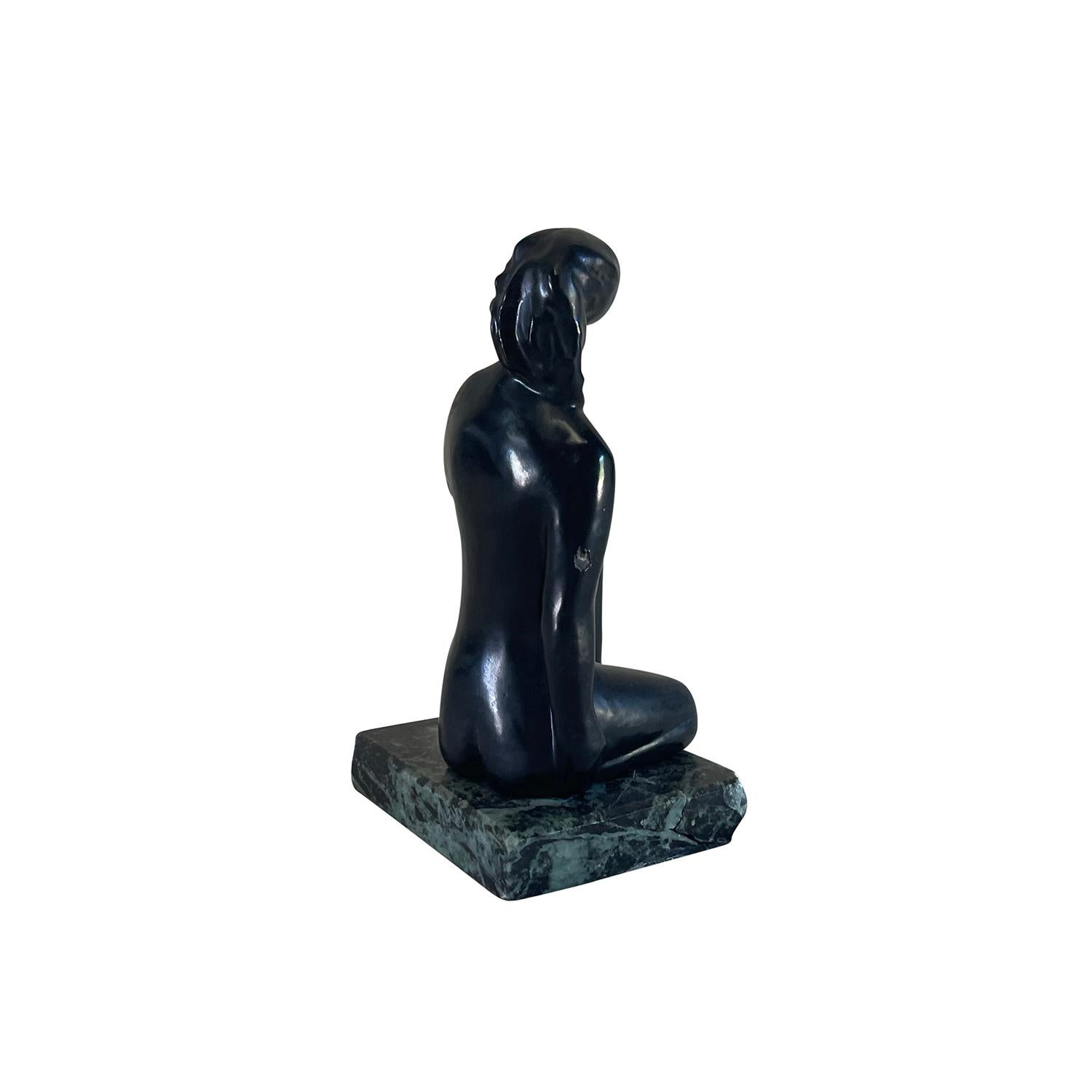 Statuetta d'epoca in stile Art Déco francese di una donna seduta in bronzo lavorato a mano, appoggiata su una base rettangolare in marmo verde di Tinos, in buone condizioni. La base presenta un'incisione 