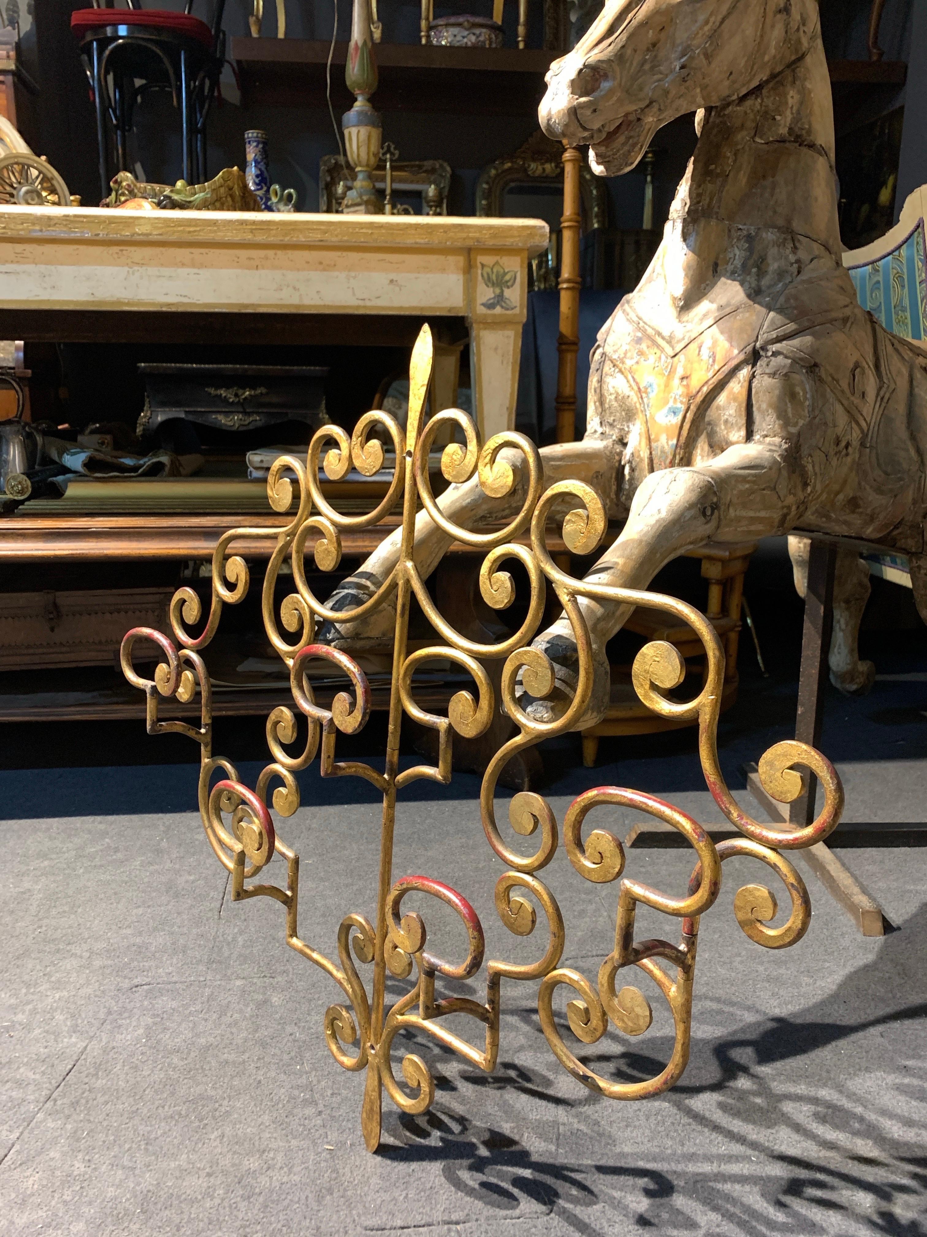 Cintre vintage en métal français avec crochets mobiles pour manteaux ou chapeaux peints en or avec des accents rouges, entièrement courbés à la main en motifs floraux. Pièce très stable et bien conservée qui pourrait être très agréable à regarder