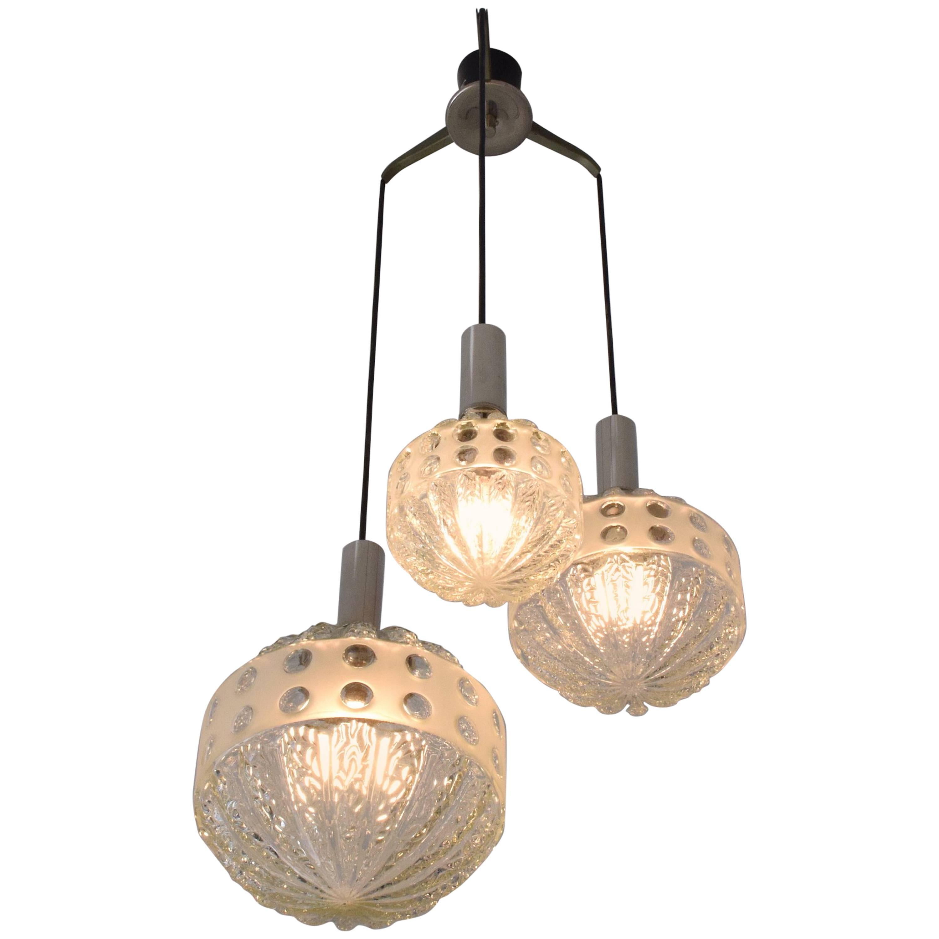 A 20th century French vintage pendant light or chandelier in Cascade style designed with three textured glass globes of various sizes and mounted on a chrome structure.
France, circa 1970s.