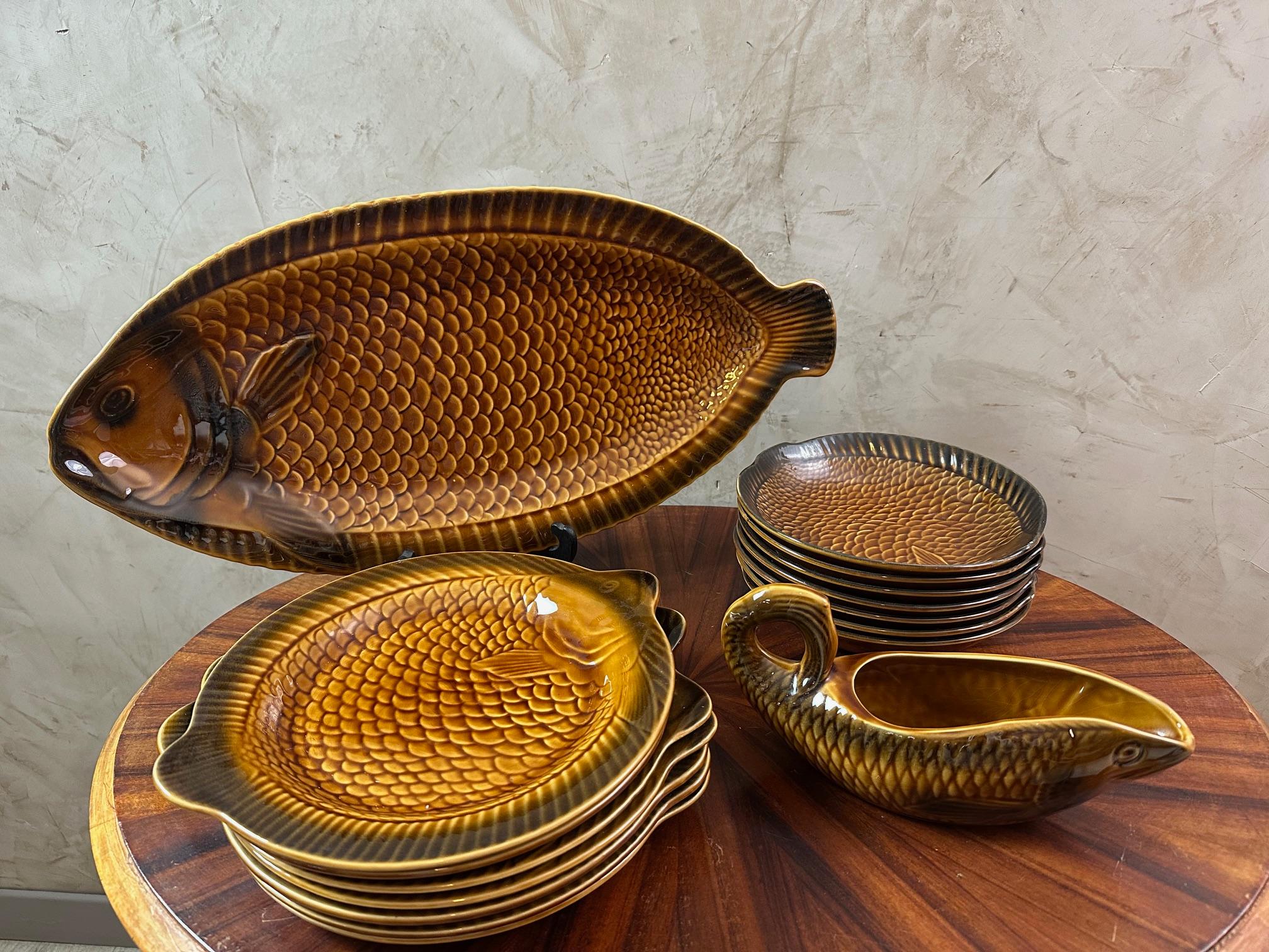Set of Mid-Century majolica or faïence fish service.
Stamped Sarreguemines France, circa 1950s.

Heavily potted, deep yellow ochre glazed earthenware bodies with deep brown rims, an iridescent glaze to the versos. Rolled rims and incised
