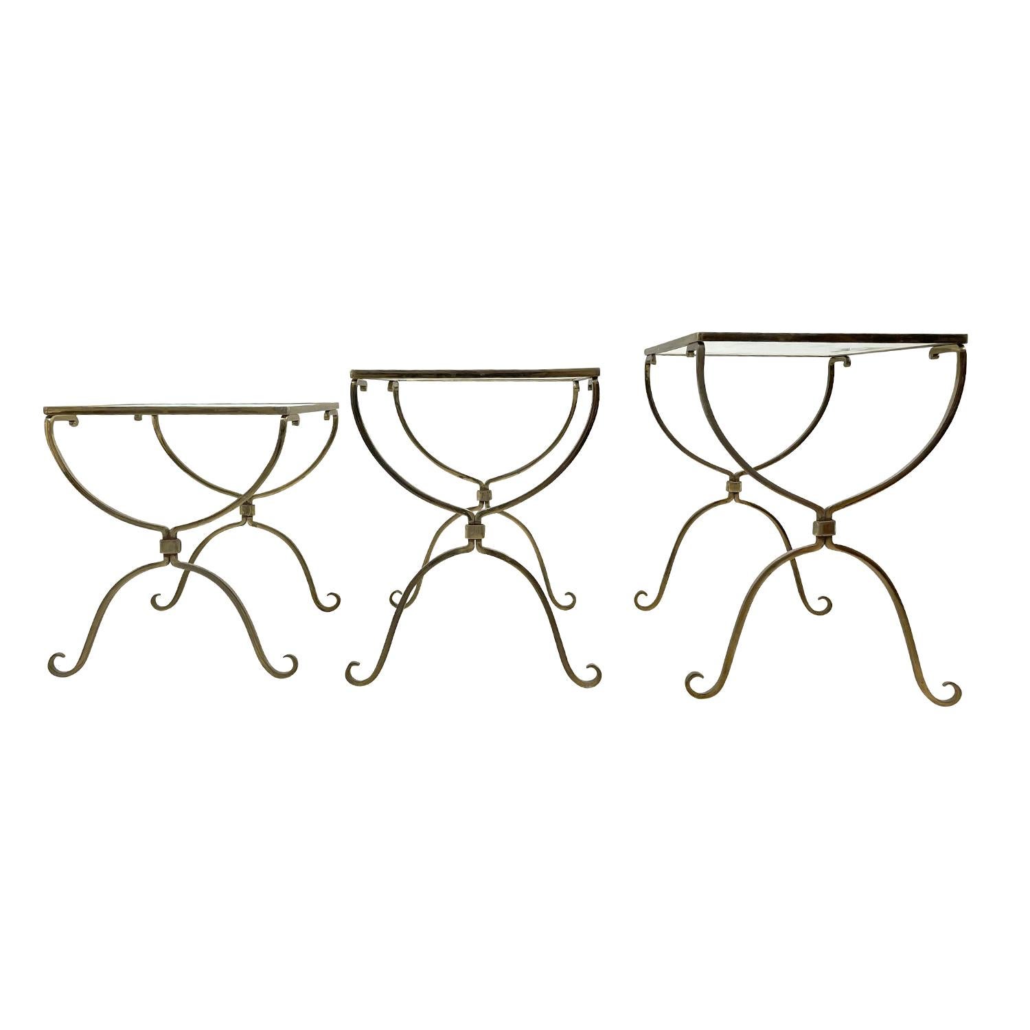 Eine goldene, Vintage Art Deco Französisch Satz von Trio Bagnes Stil Verschachtelung Tabellen aus handgefertigtem Messing, in gutem Zustand. Die detaillierten kleinen Beistelltische sind mit der originalen Rauchglasplatte ausgestattet. Leichte