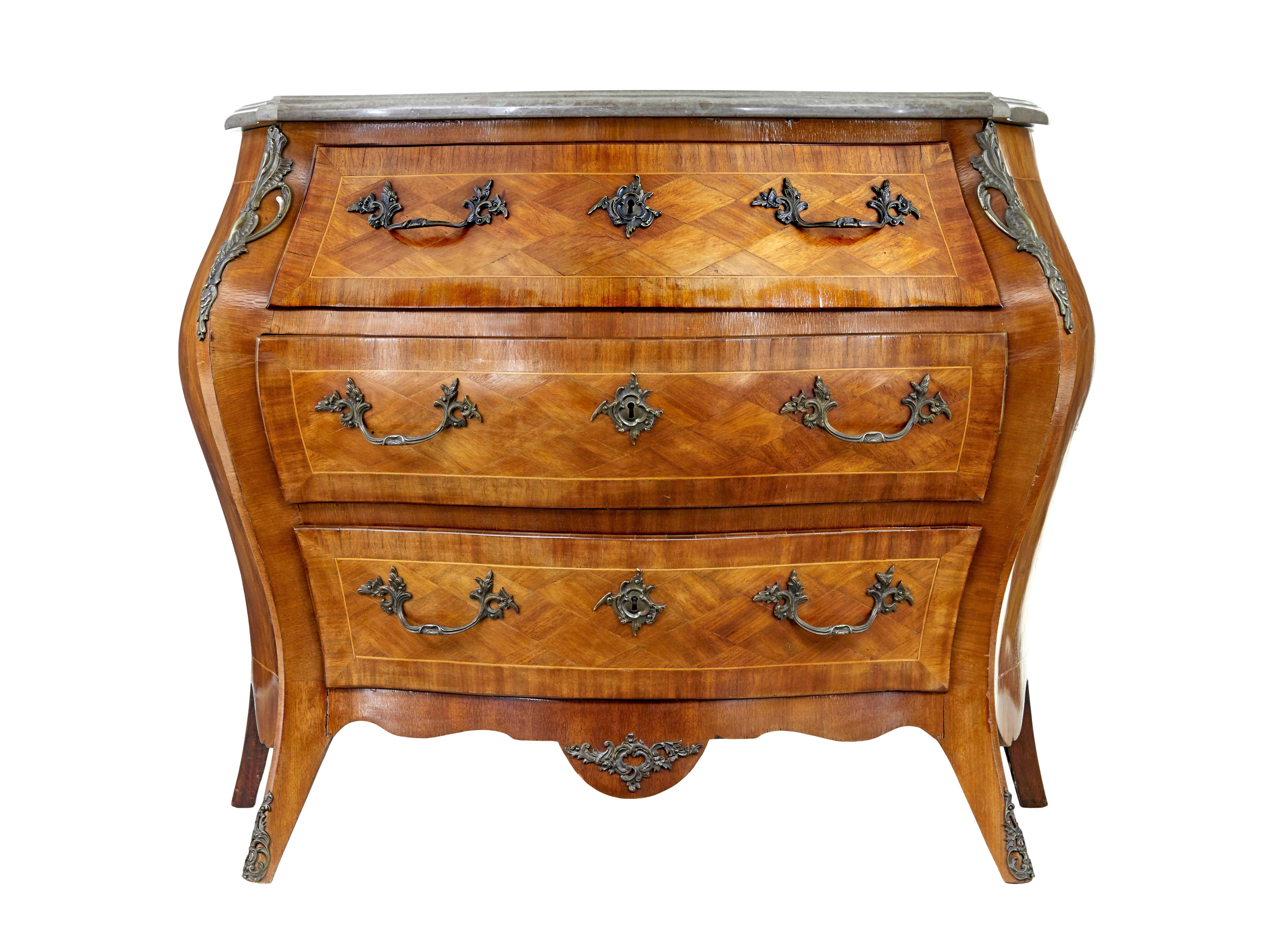Mid century French walnut marble-top commode circa 1950.

Good quality french bombe shaped commode in the rococo taste.  3 drawers fitted with ornate handles and key plates. Parquet arranged drawer fronts and sides and stringing. Grey marble top