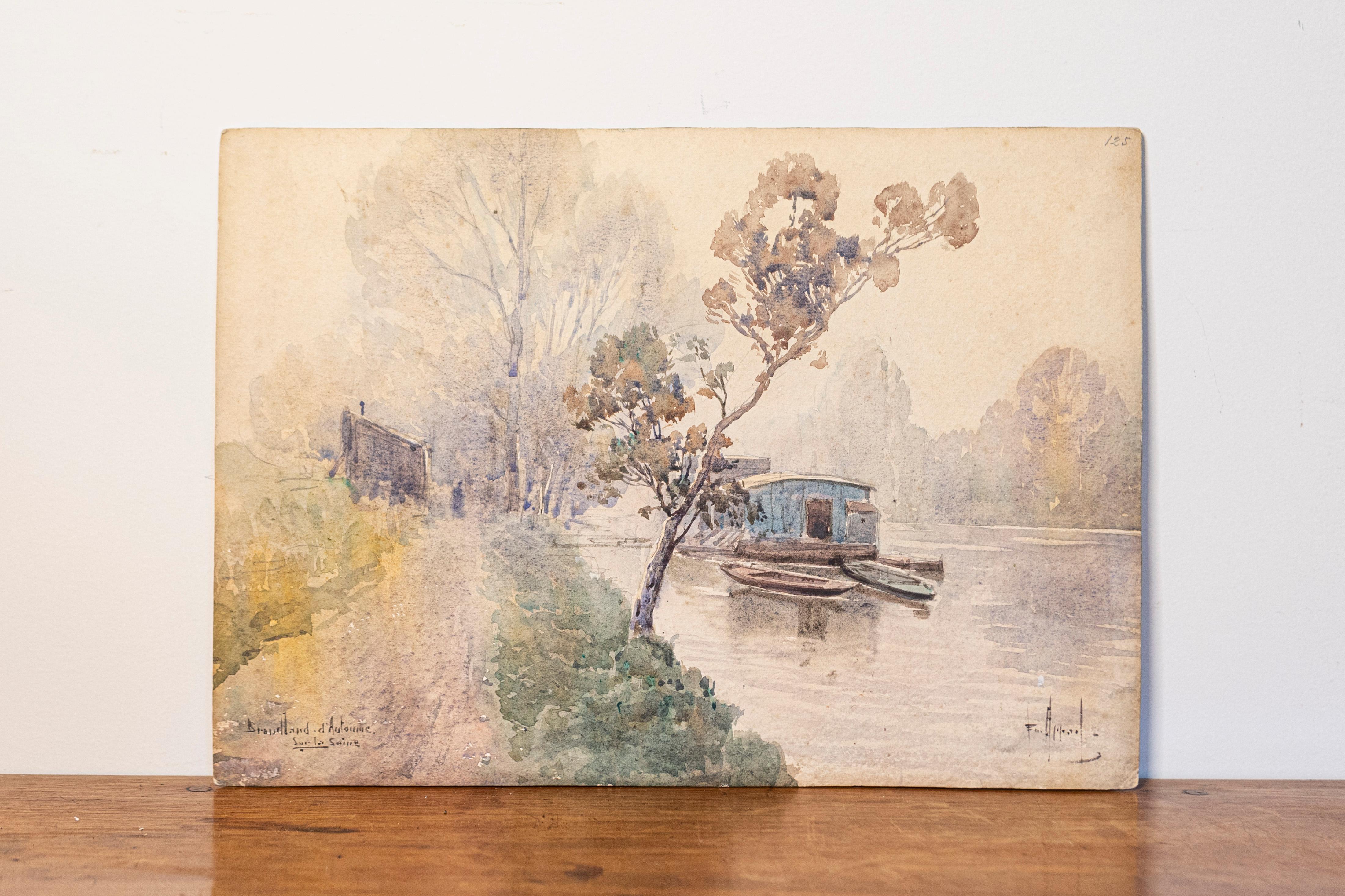 This 20th-century French watercolor captures a serene riverside scene in soft, muted tones, evoking a sense of tranquility. The painting showcases a peaceful pathway leading to a small, rustic building beside the water, with boats resting along the