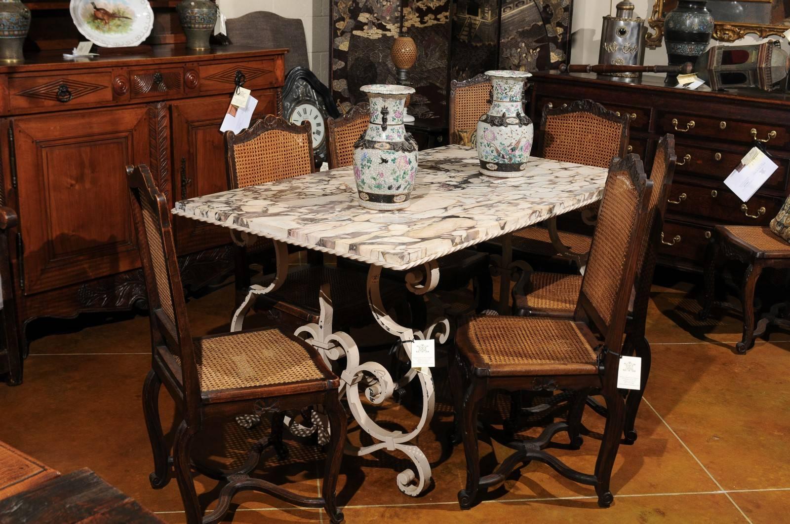 Iron garden/outdoor dining table in distressed white-pained finish with scroll detail and stretcher. A twisted border surrounds the rectangular marble top in variegated hues of whites, grays, and purples. The table dates from 20th century, France.