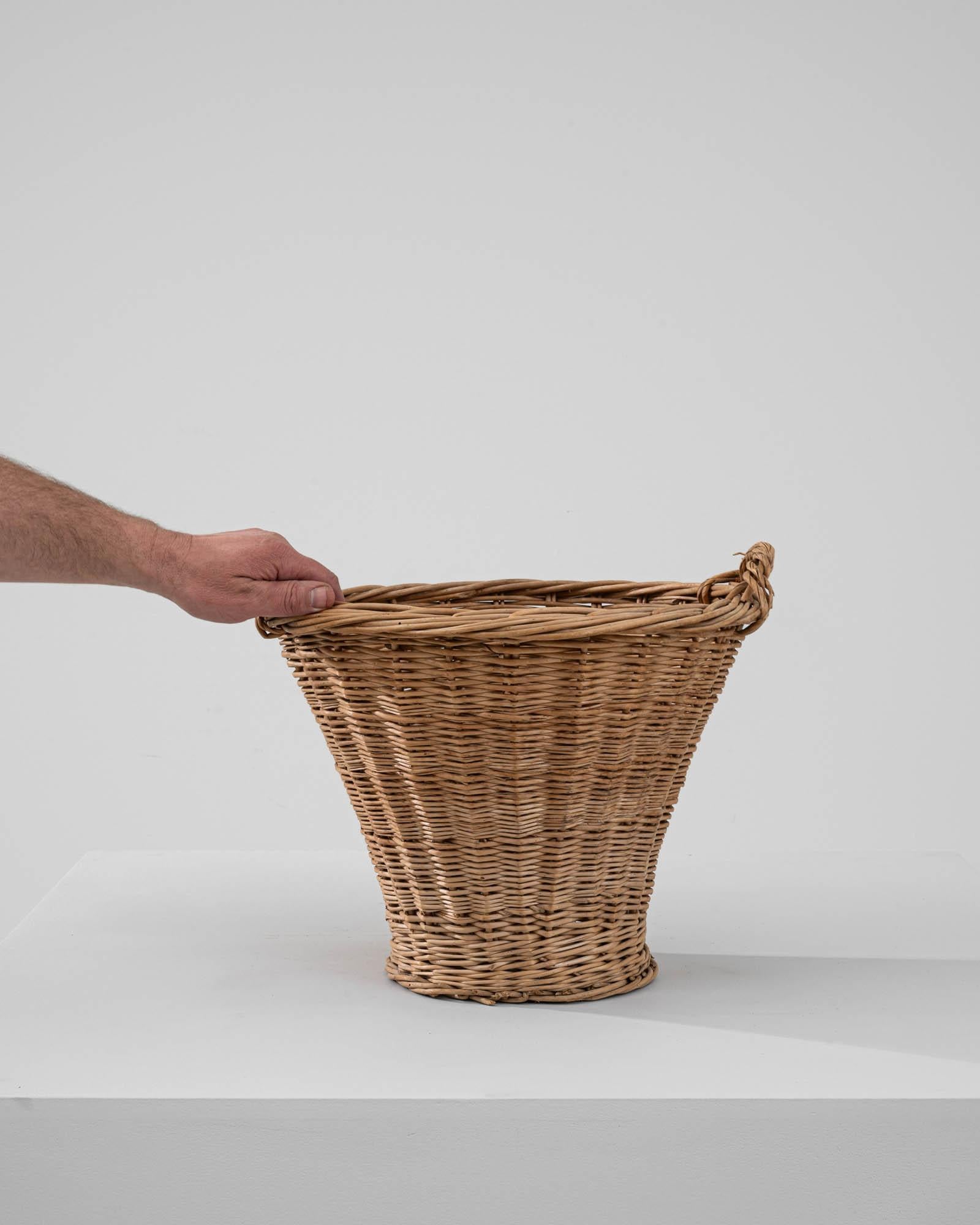 Elevate your space with the timeless allure of our 20th Century French Wicker Basket. Crafted with care, this exquisite piece exudes vintage charm, adding character to any room it graces. Featuring short handles, it offers both practicality and