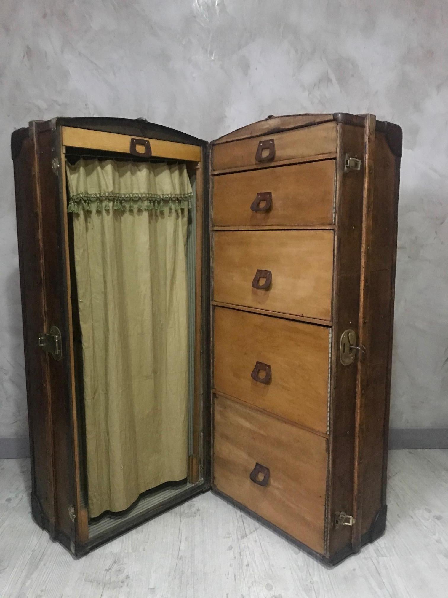 Beautiful and rare 20th century French wood and gilded brass cabin wardrobe or trunk from the 1920s.
Has been restored. When you open the trunk you find five upholstered drawers on the right and a wardrobe on the left closed by a silk fabric, the
