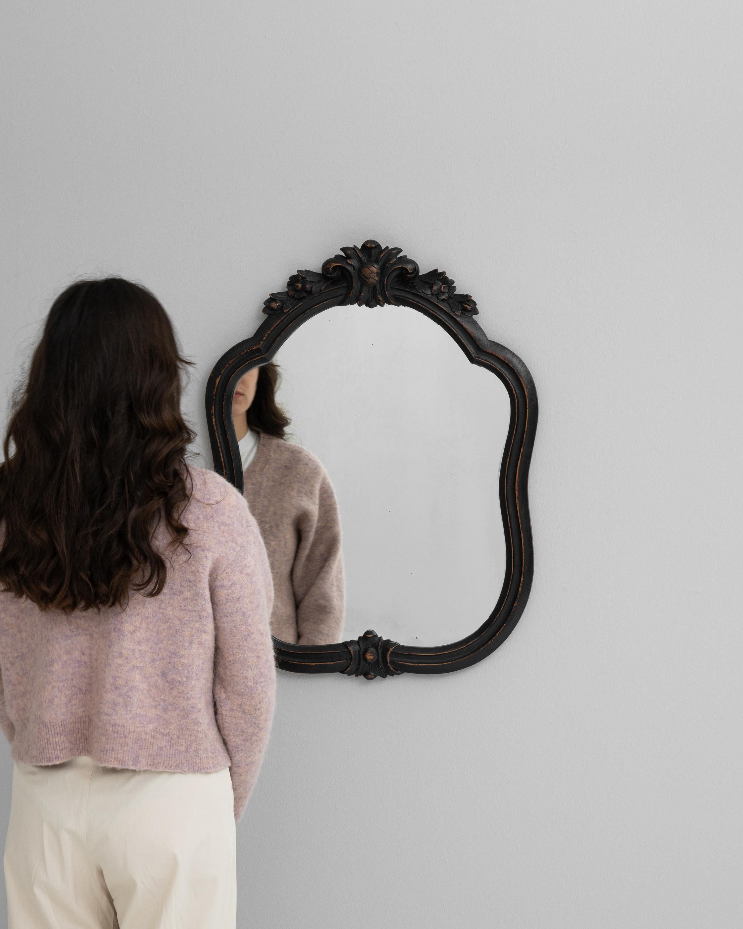 Step into a world where classic design meets timeless elegance with this 20th Century French Wood Black Patinated Mirror. The sculptural frame, black with a hint of patina, showcases the meticulous craftsmanship of the period with its delicate