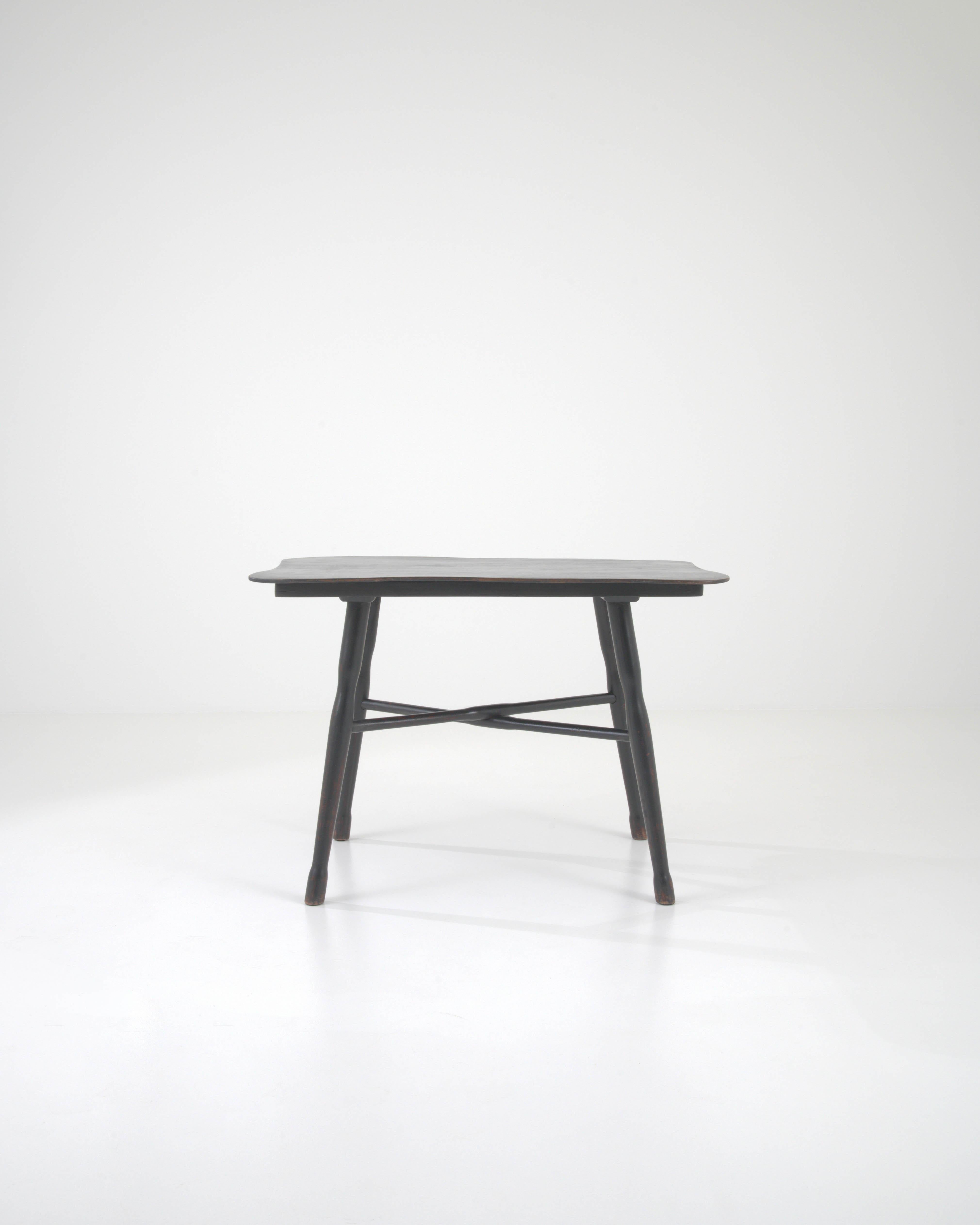 Introducing the epitome of vintage charm and character, our 20th Century French Wood Black Patinated Side Table. Masterfully crafted from high-quality wood, this side table boasts a rich black patina that exudes an air of timeless elegance. Its