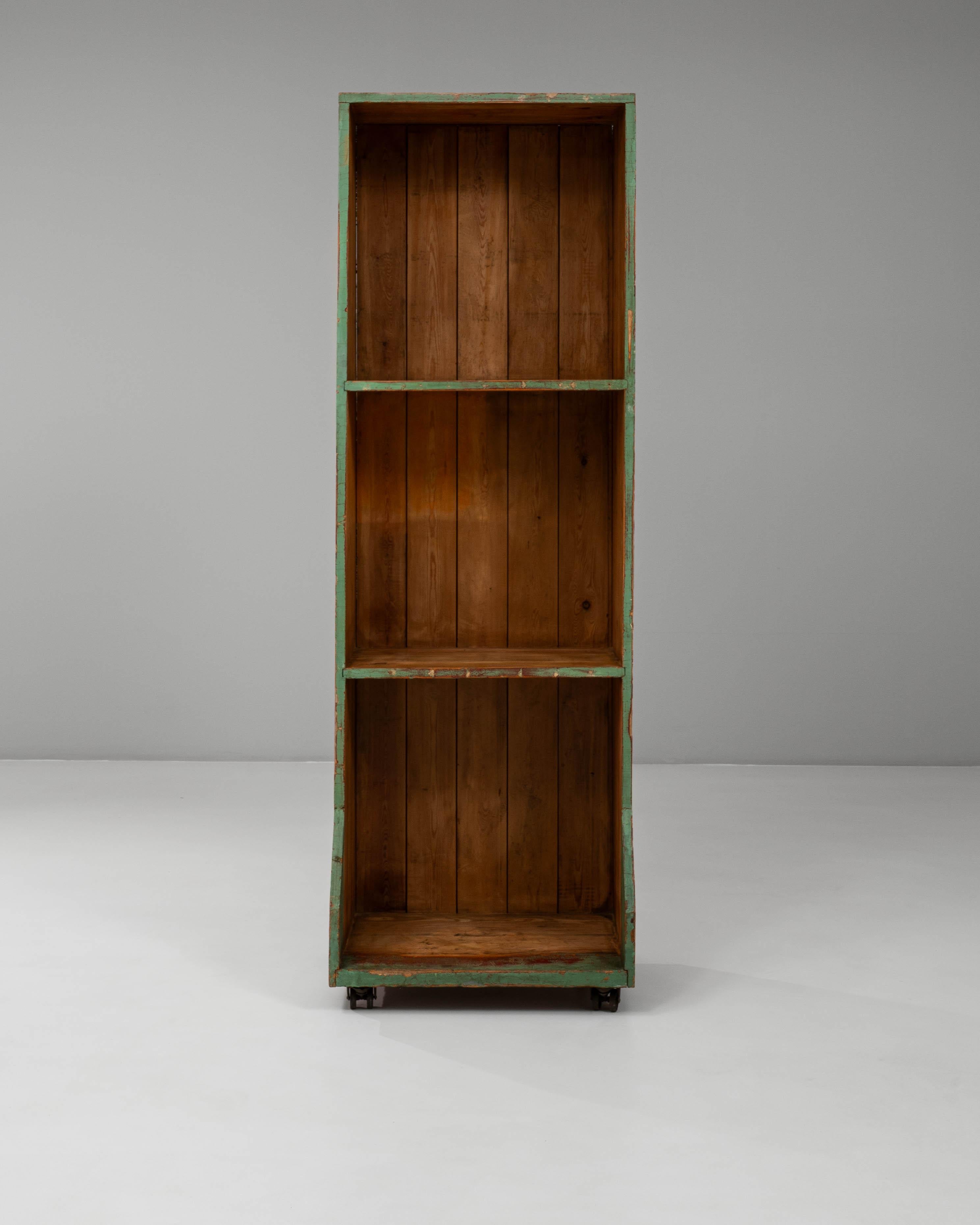 Questa libreria francese in legno del XX secolo presenta un'affascinante finitura patinata che ne evidenzia le origini utilitarie e il carattere rustico. Realizzato con un'alta struttura rettangolare e scaffali aperti, offre un pratico spazio di