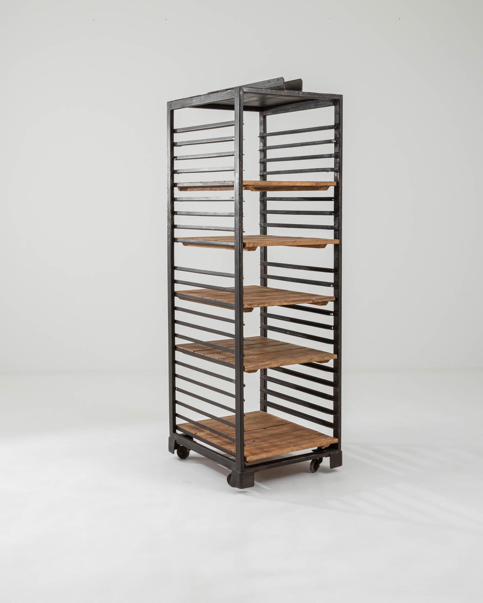 A metal and wooden set of shelves created in 20th century France. With both an industrial and homey quality, this delightful set of shelves projects a sense of both forthright purpose and a cozy warmth. Created entirely from steel and slats of