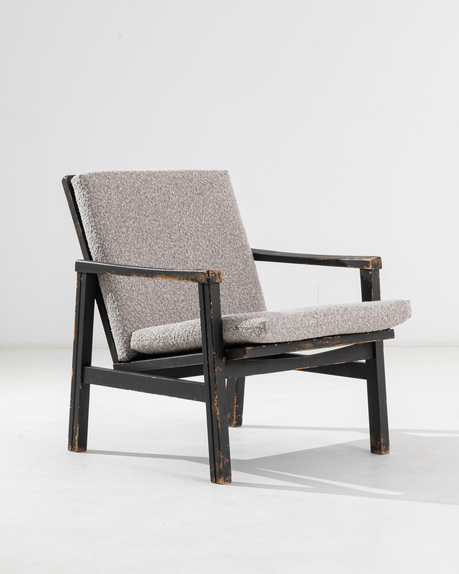 This vintage Mid-century Modern armchair offers a bold, eye-catching design in soothing natural materials. Made in France in the 20th century, the wooden frame is lightweight yet packs a graphic punch. A-frame legs support a ‘floating’ seat, set at