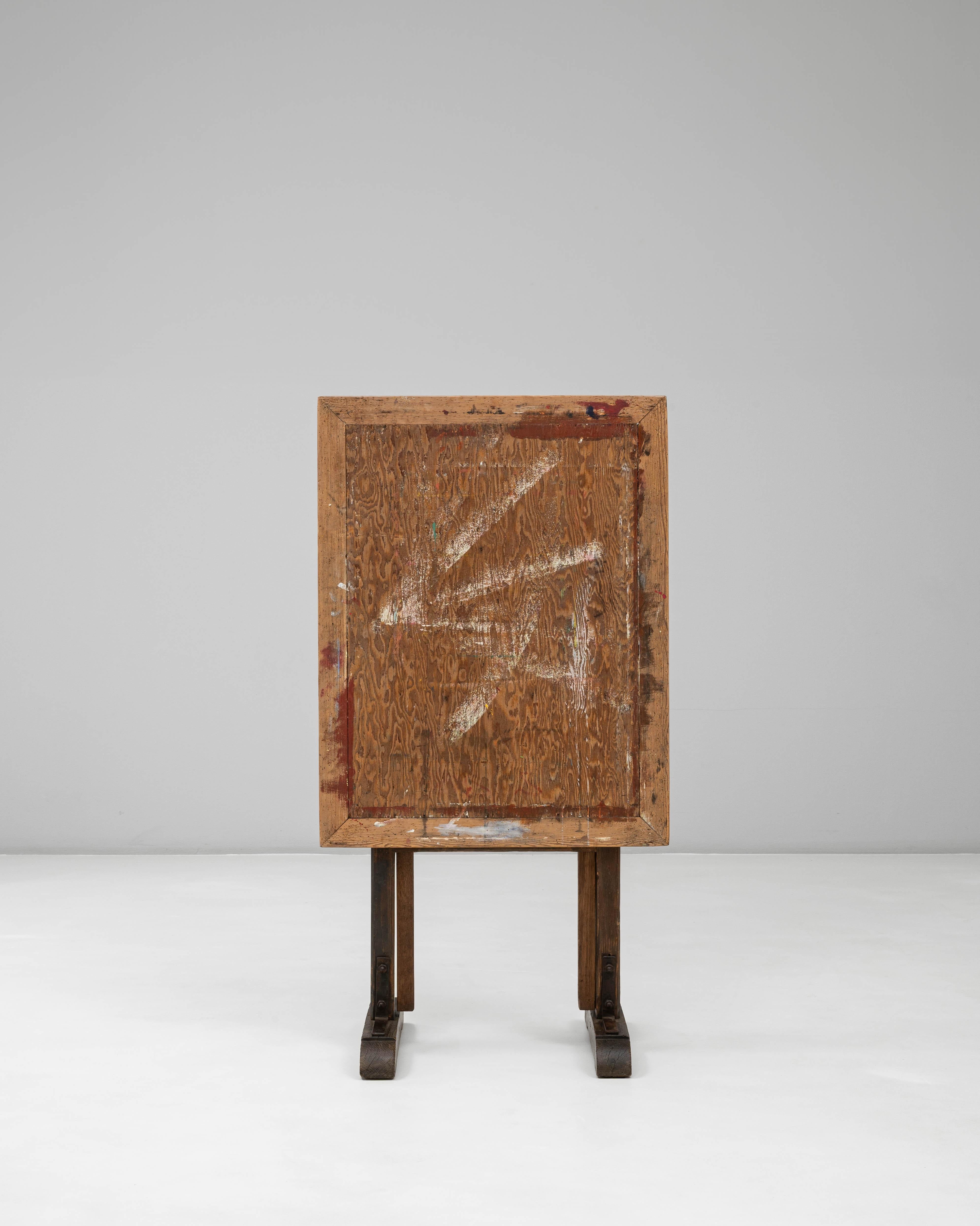 Ce chevalet d'artiste en bois français du XXe siècle présente une surface joliment usée par le temps et une conception pratique et réglable qui reflète des décennies d'utilisation en studio. Construit en bois massif, le chevalet repose sur des pieds