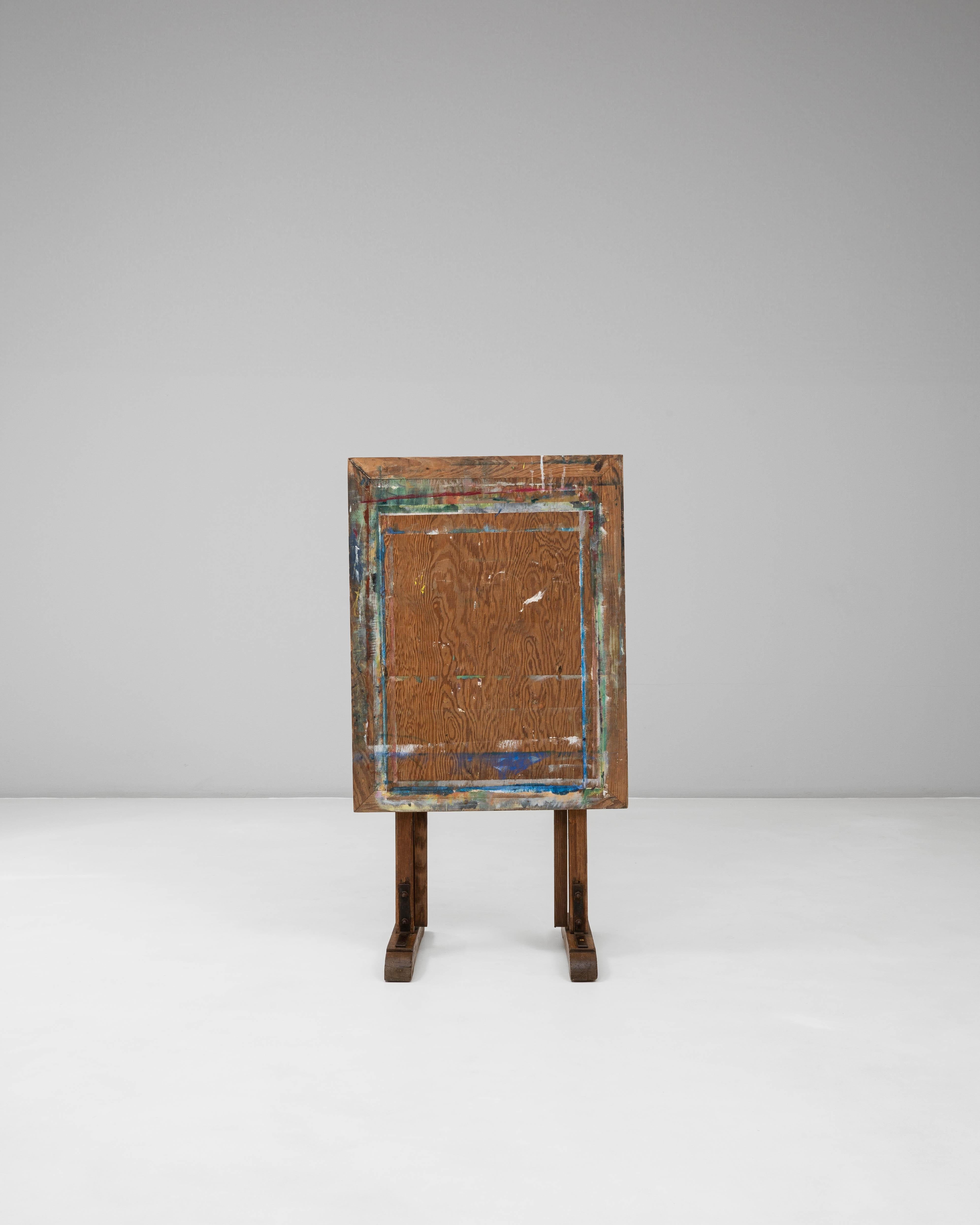 Ce chevalet d'artiste en bois français du XXe siècle présente une surface joliment usée par le temps et une conception pratique et réglable qui reflète des décennies d'utilisation en studio. Construit en bois massif, le chevalet repose sur des pieds